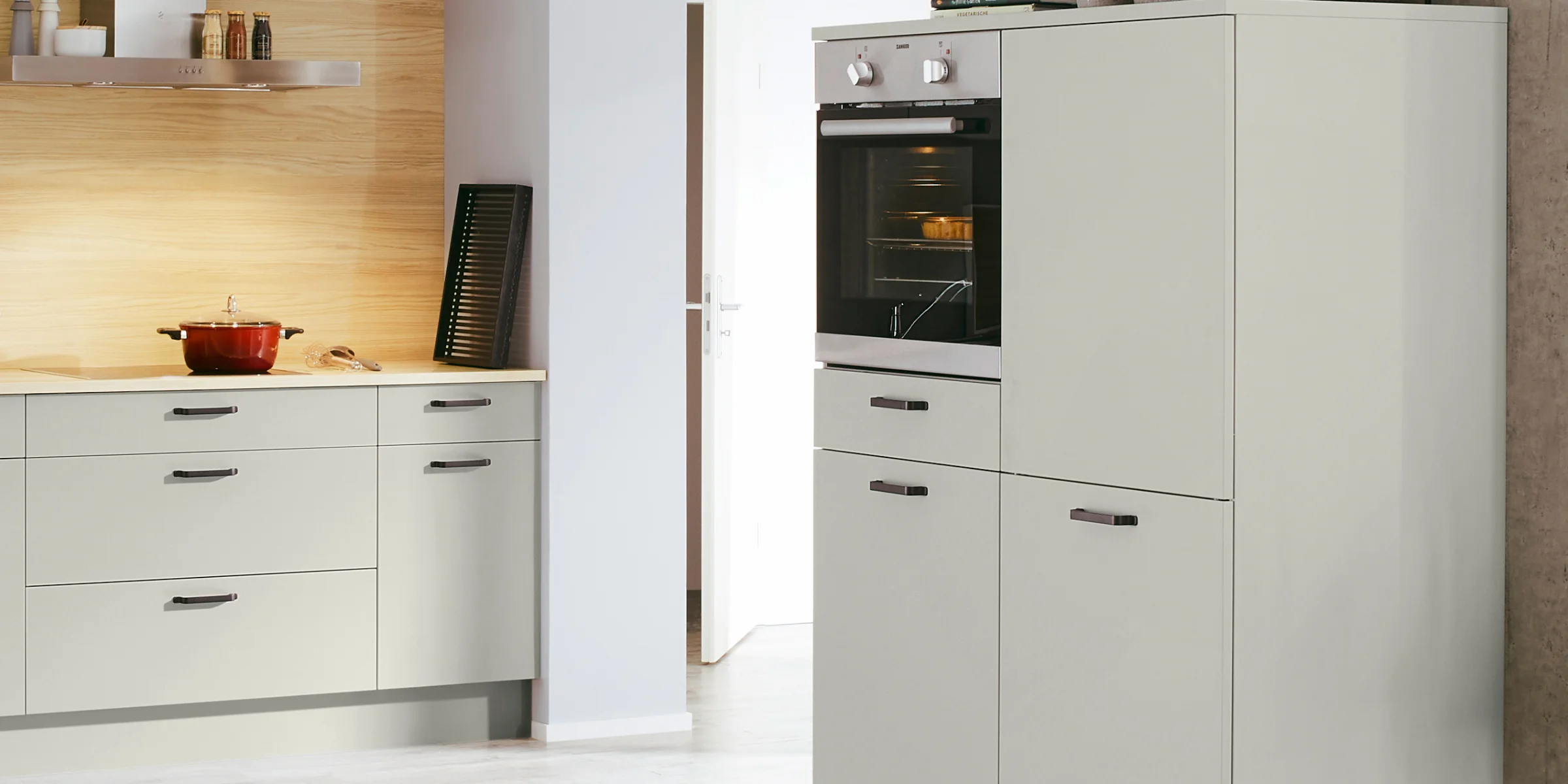 Cucina moderna e luminosa con elettrodomestici integrati e accenti in legno, ideale per Nolte Kitchen.