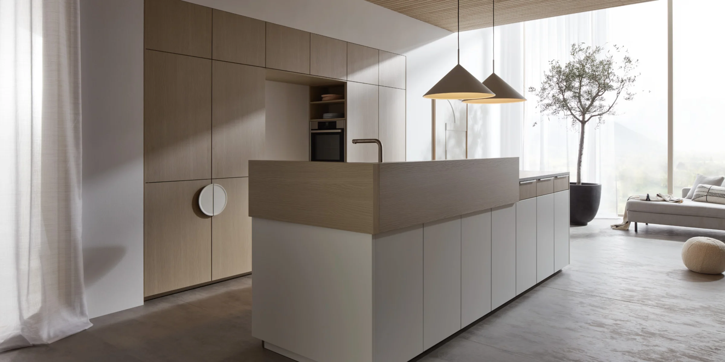 Cucina moderna con isola e dettagli in legno, illuminata da lampade a sospensione. Nolte Kitchen.