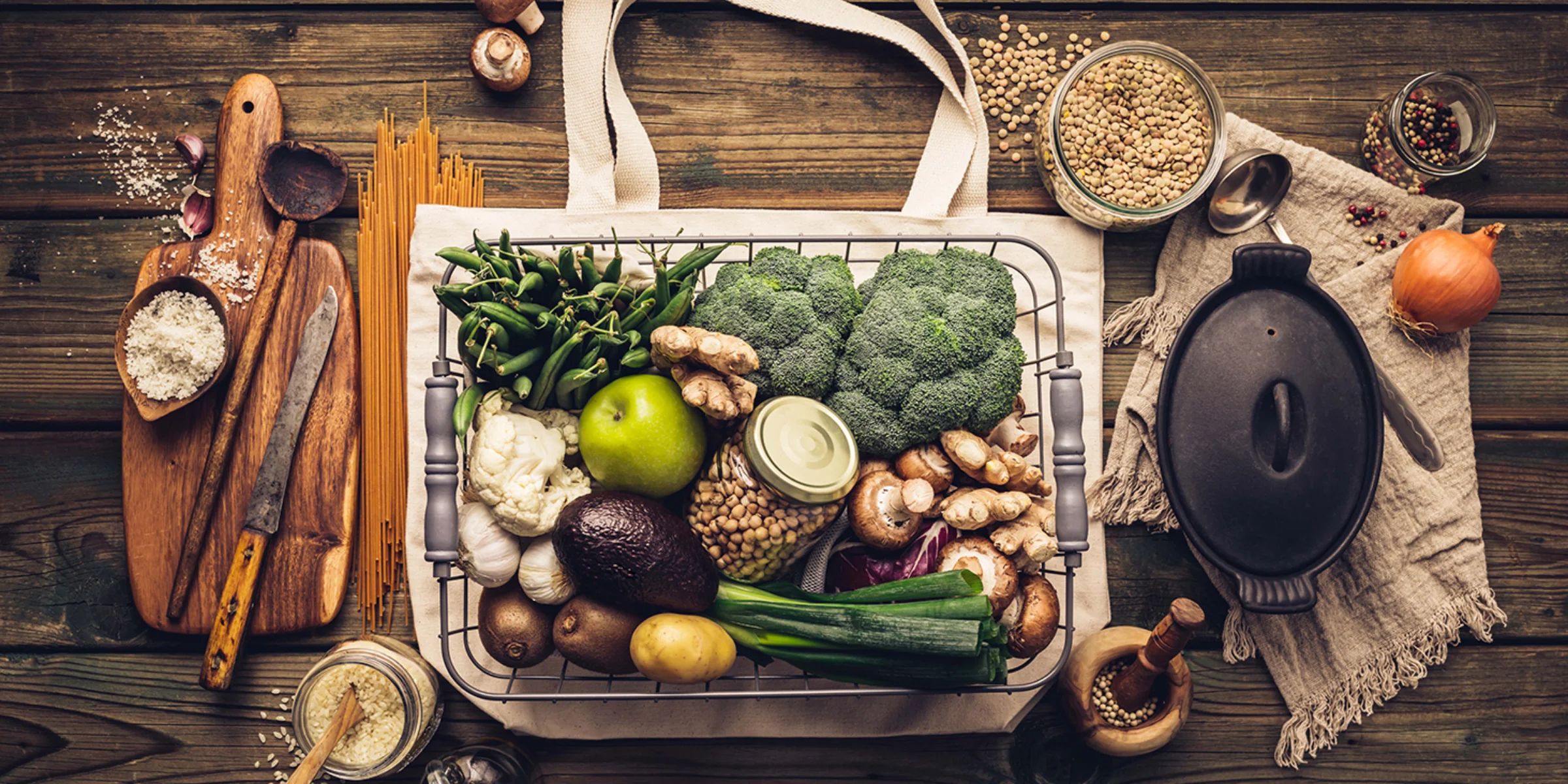 Una selezione di verdure fresche e ingredienti su un tavolo di legno.
