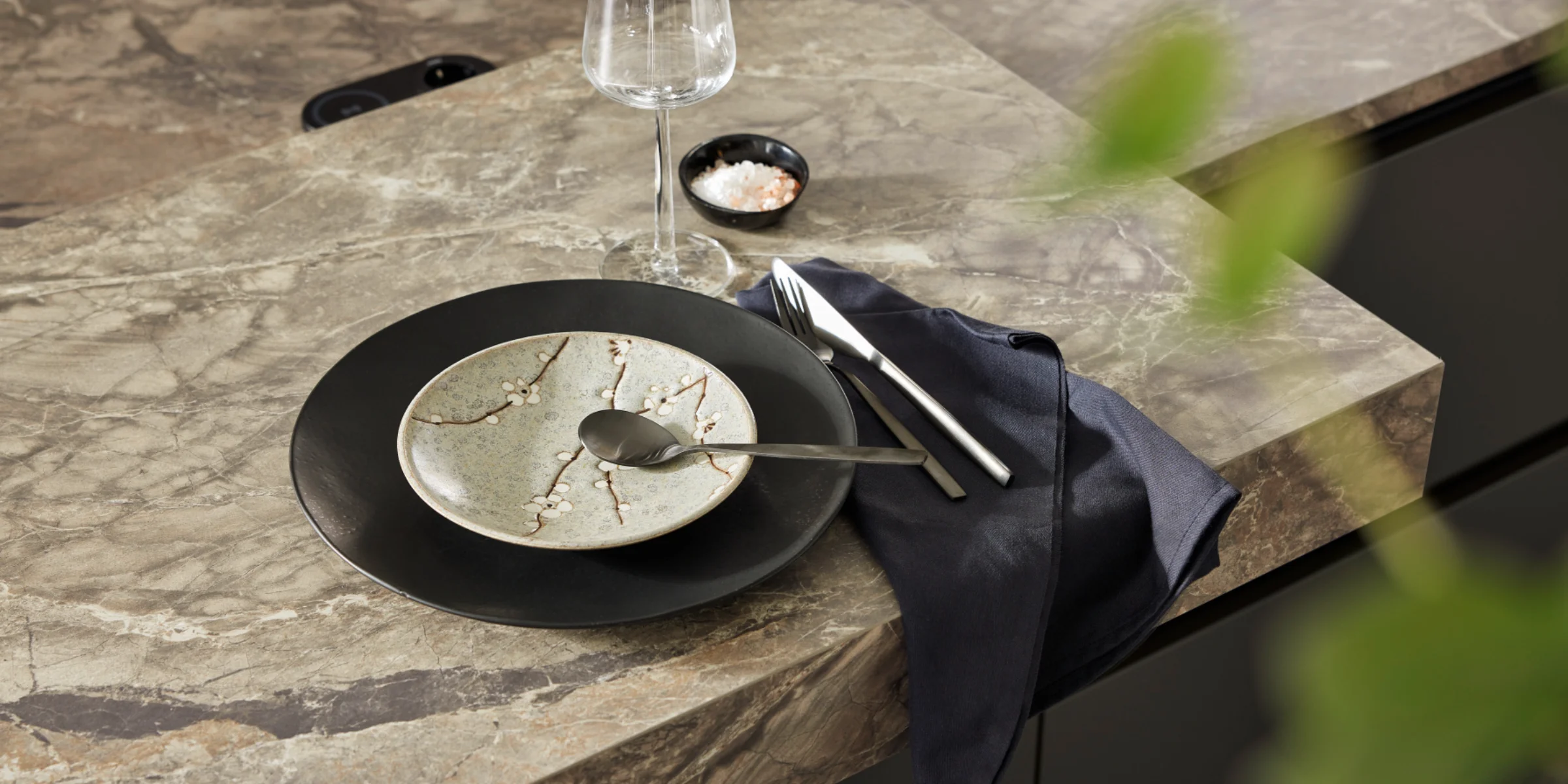 Tavolo elegante con stoviglie moderne su un piano cucina di Nolte Kitchen.