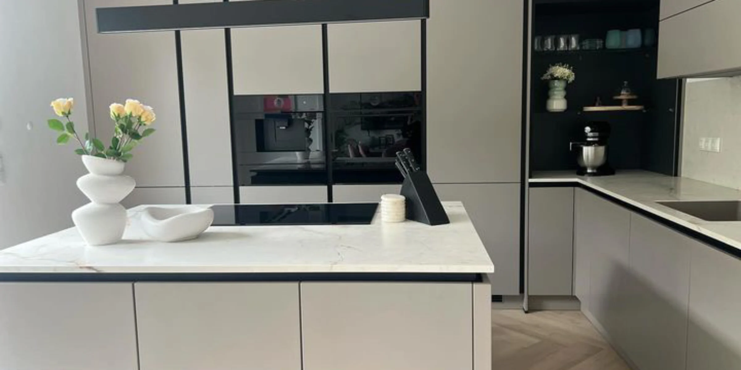 Cucina moderna con armadi grigi e isola, elegantemente arredata da Nolte Kitchen.