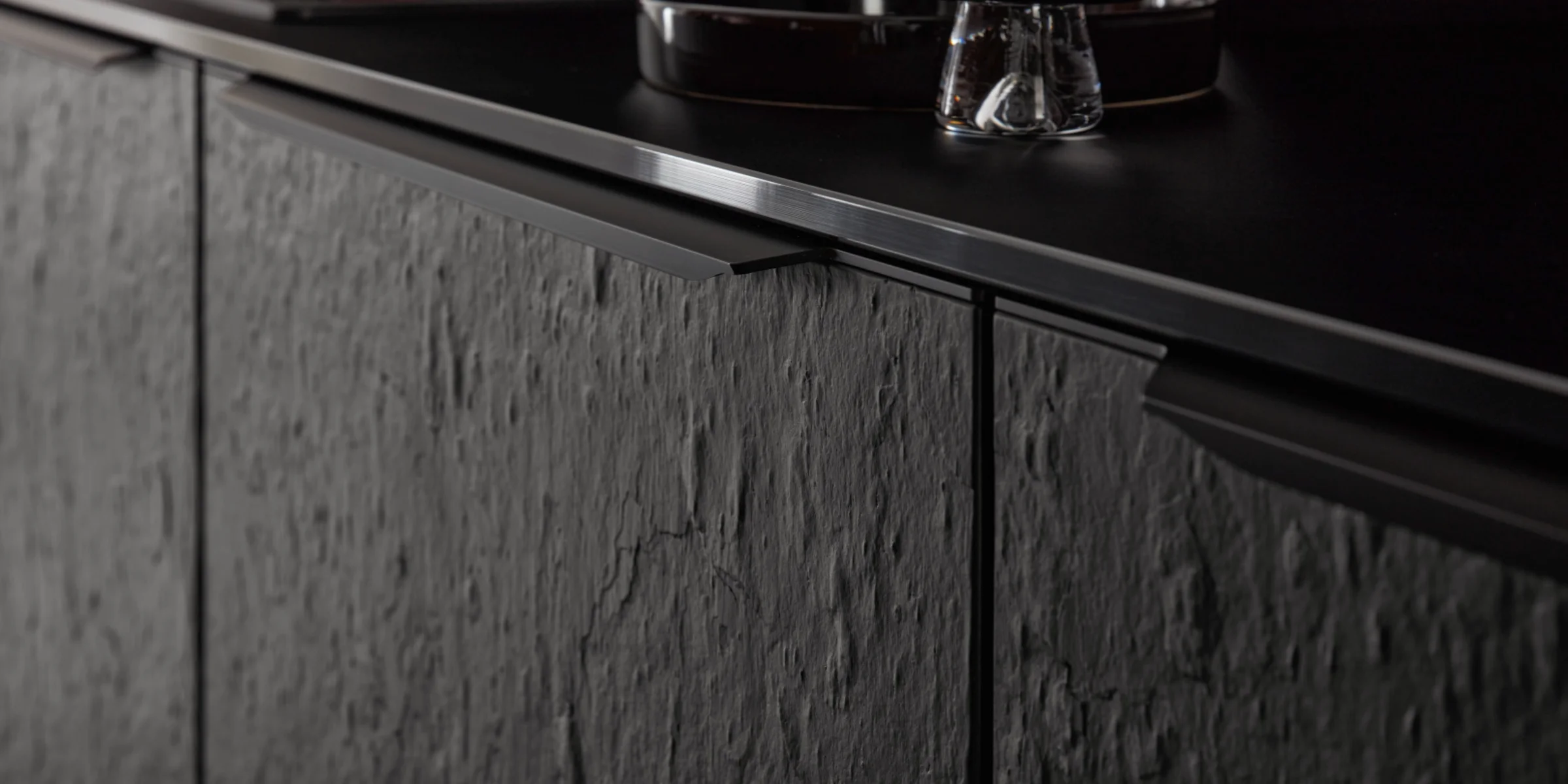 Cucina moderna con frontali scuri e strutturati e dettagli eleganti di Nolte Kitchen.