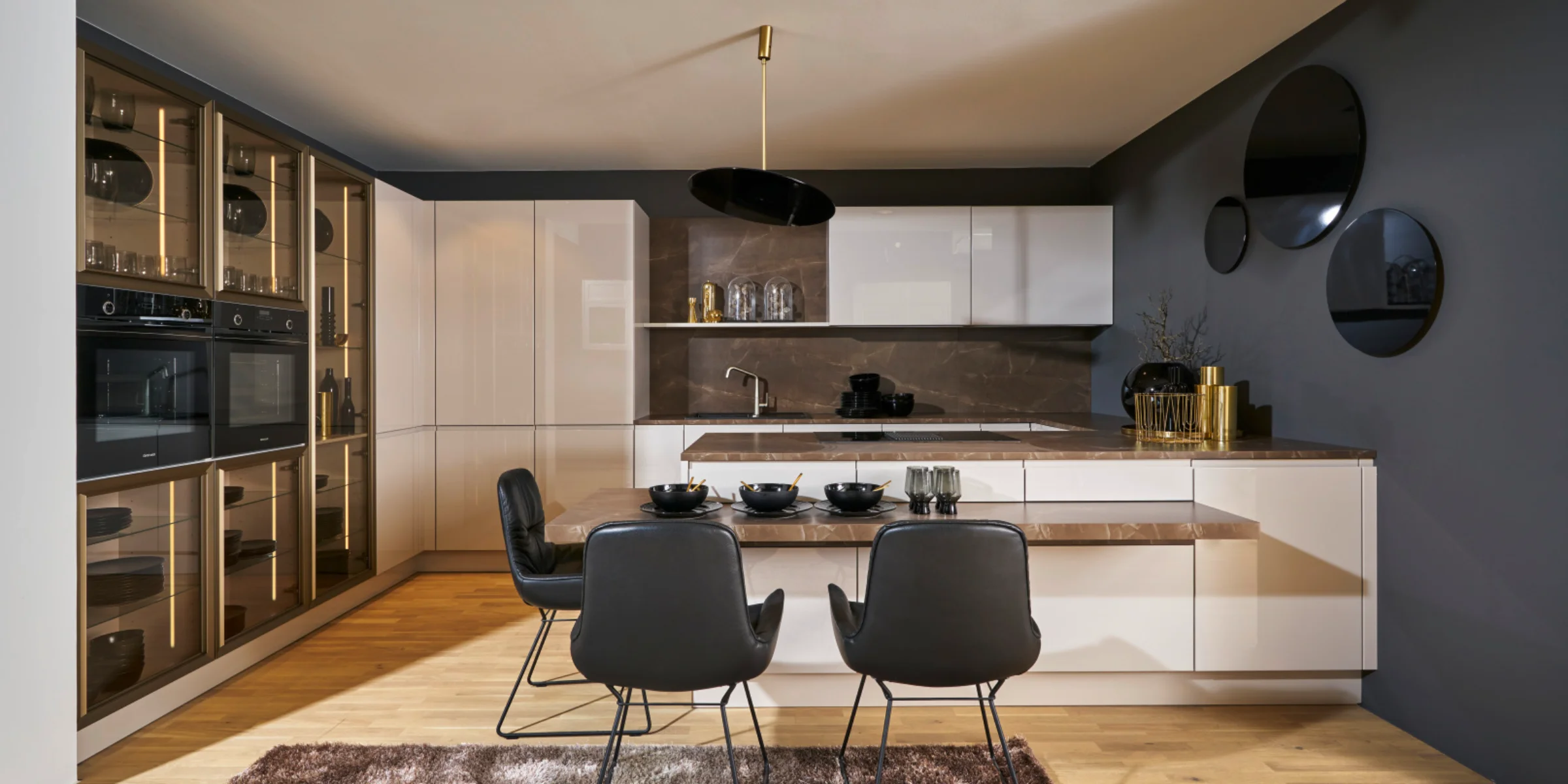 Cucina moderna con tavolo e sedie nere, eleganti armadi e decorazioni di Nolte Kitchen.