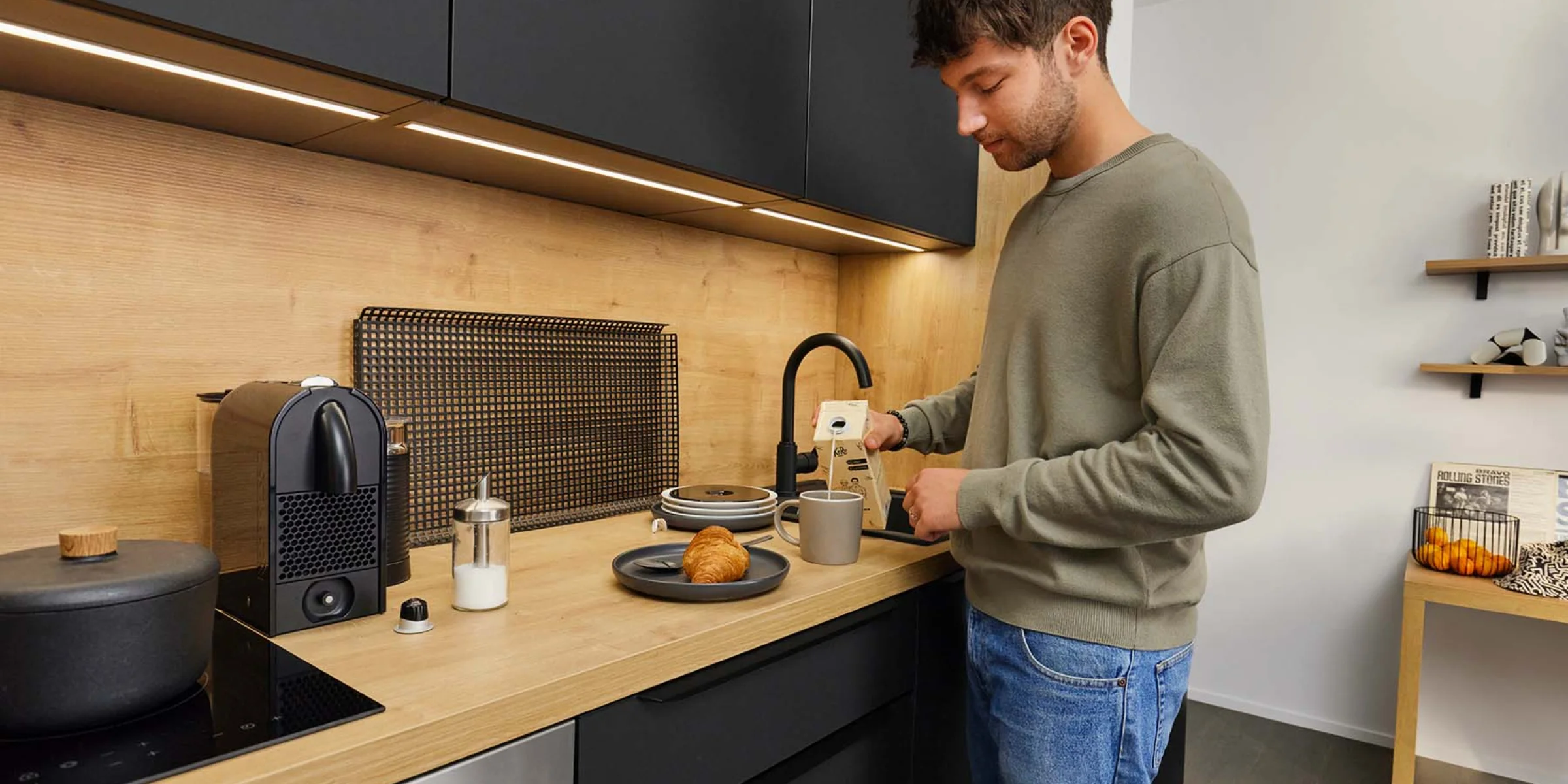 Un uomo prepara il caffè in una cucina moderna di Nolte Kitchen.
