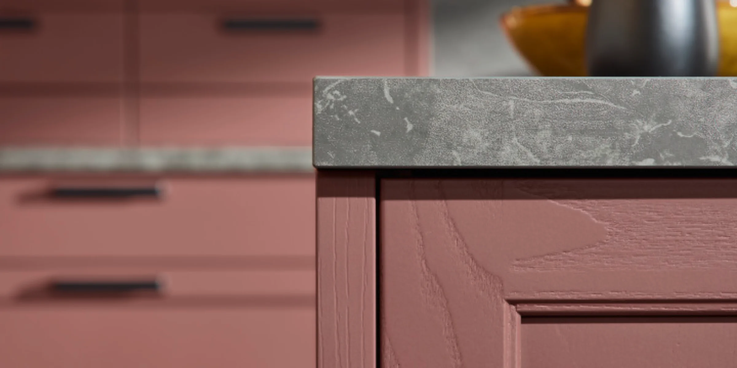 Cucina elegante con armadi rosa e piano di lavoro grigio, presentata da Nolte Kitchen.