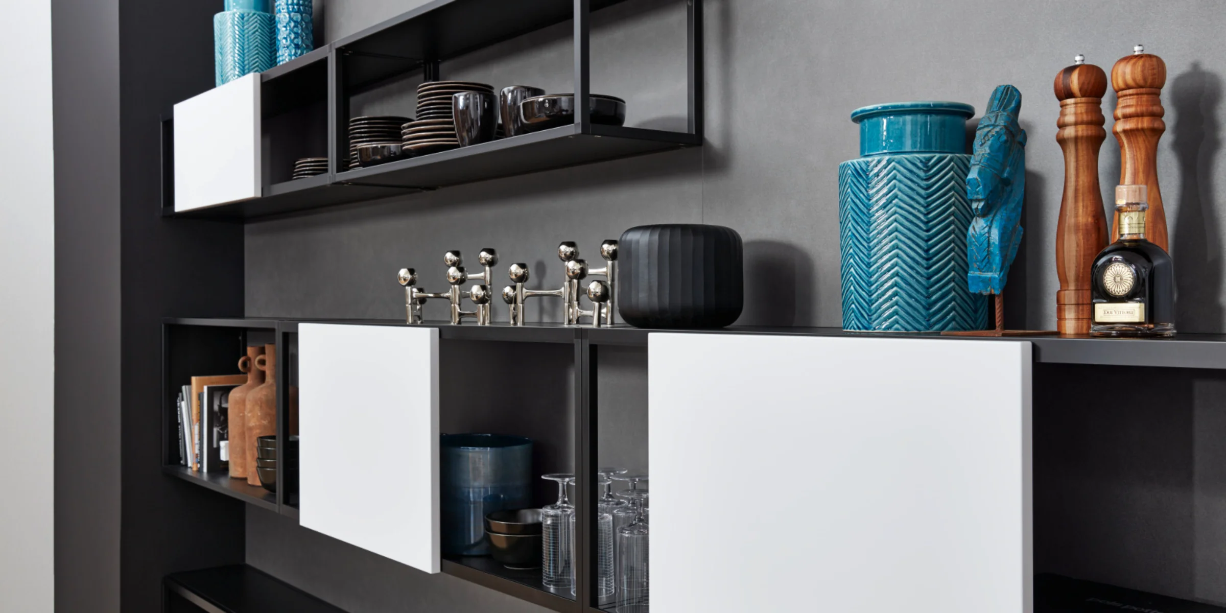 Modern living furniture with open shelves and decor, presented by Nolte Living.