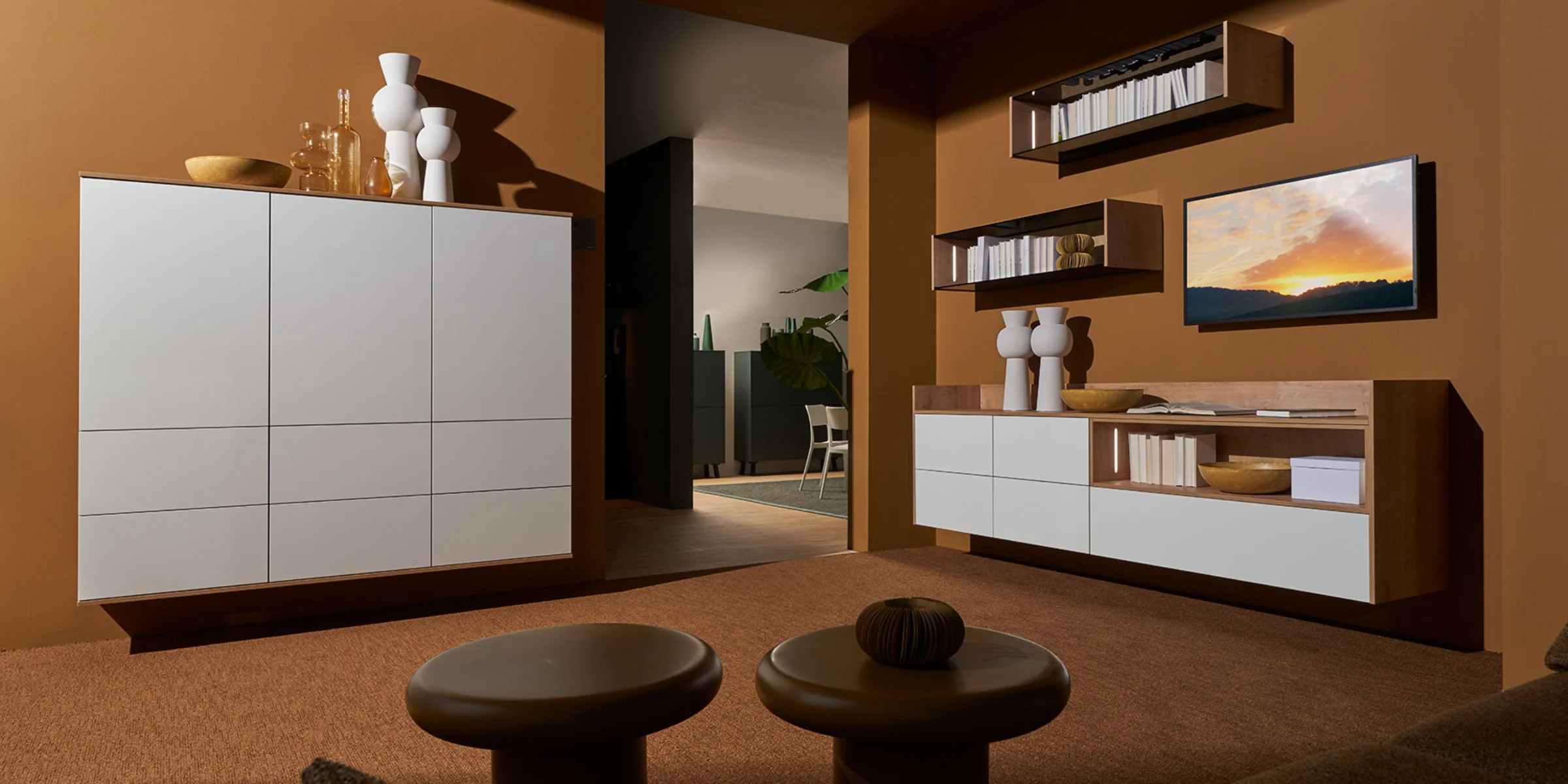 Elegante zona giorno con armadi e scaffali bianchi di Nolte Living.