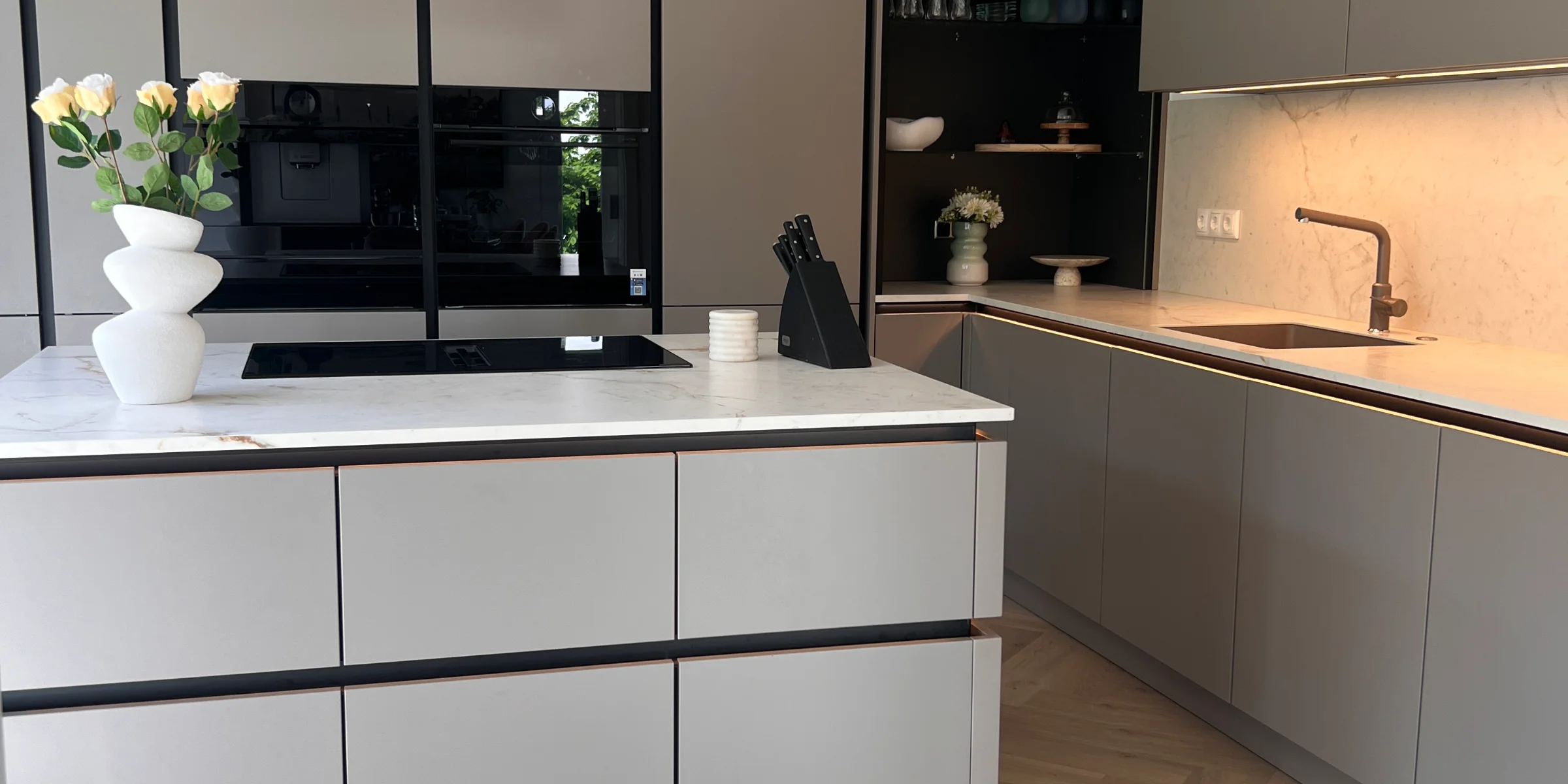 Cucina moderna con armadi grigi e isola centrale. Cucine Nolte.