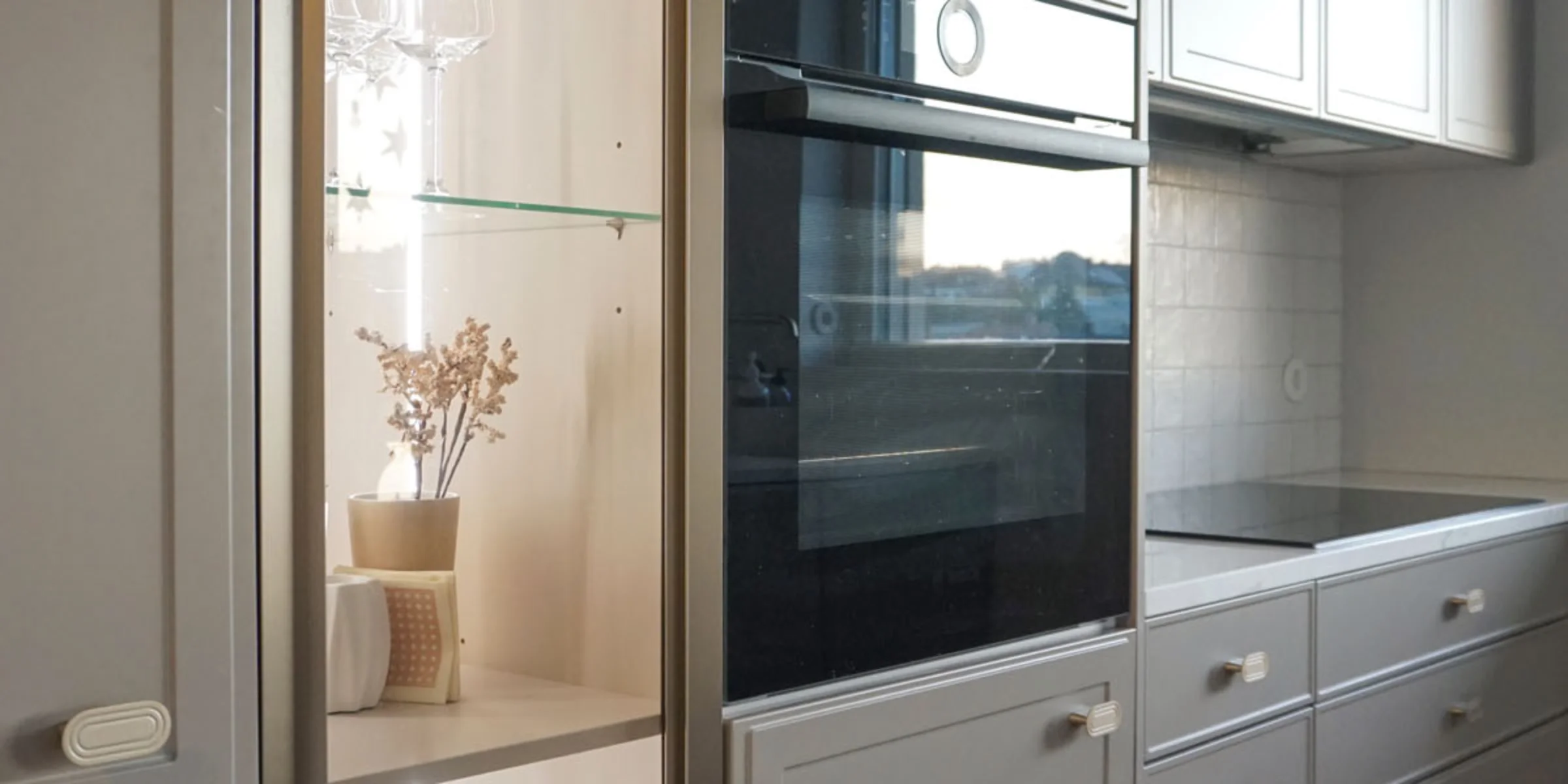 Cucina moderna con armadi grigi e forno integrato, presentata da Nolte Kitchen.