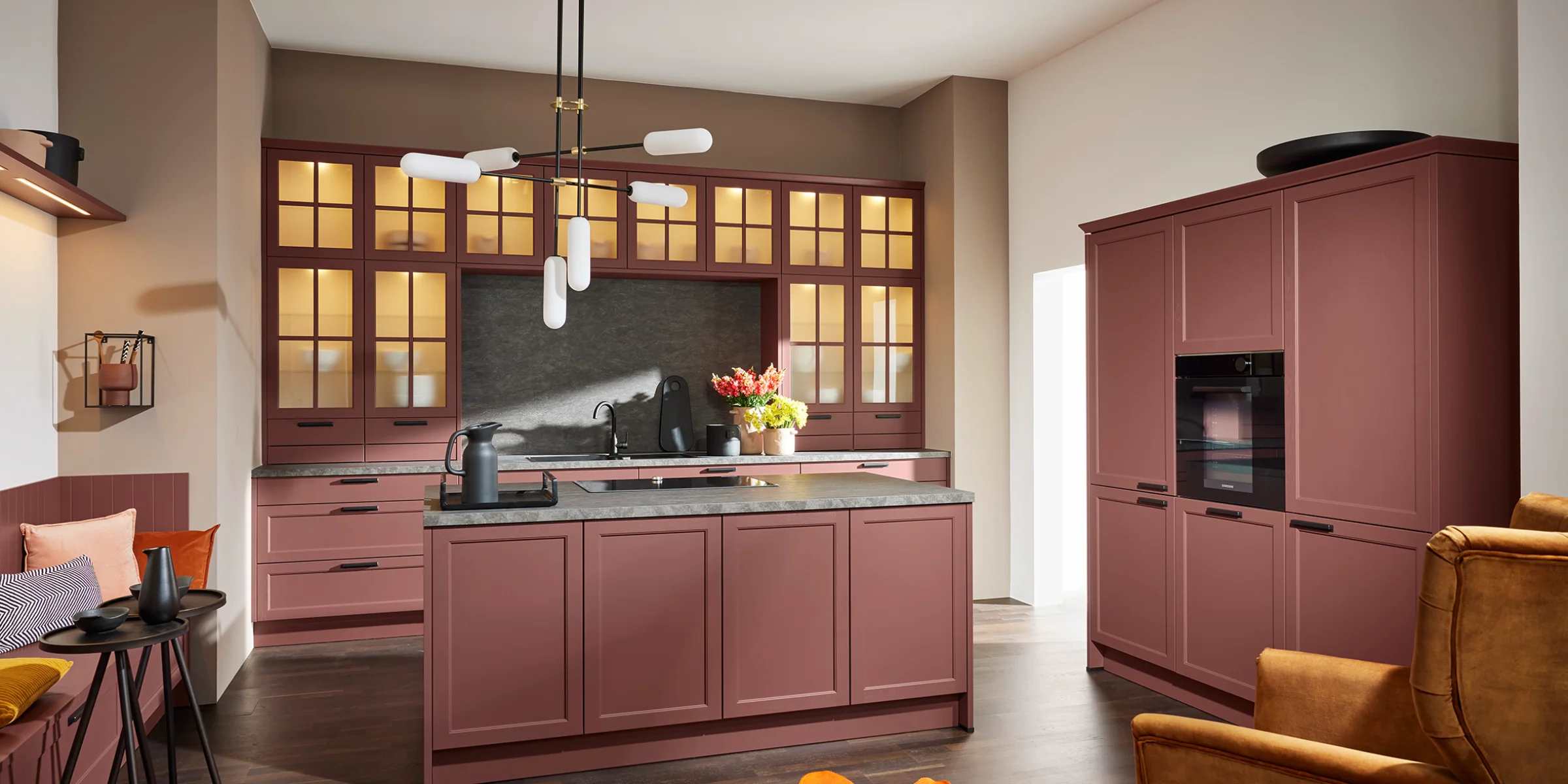 Cucina moderna in tonalità calde con isola centrale e eleganti armadi di Nolte Kitchen.