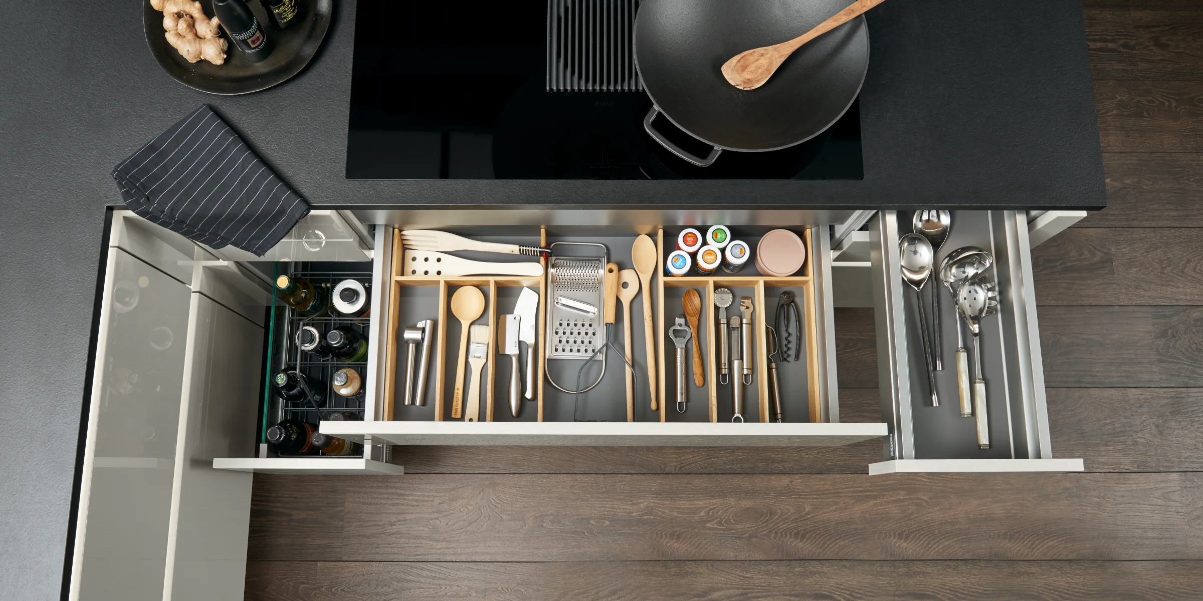 Cassetto da cucina aperto con posate e utensili ordinati, parte di Nolte Kitchen.