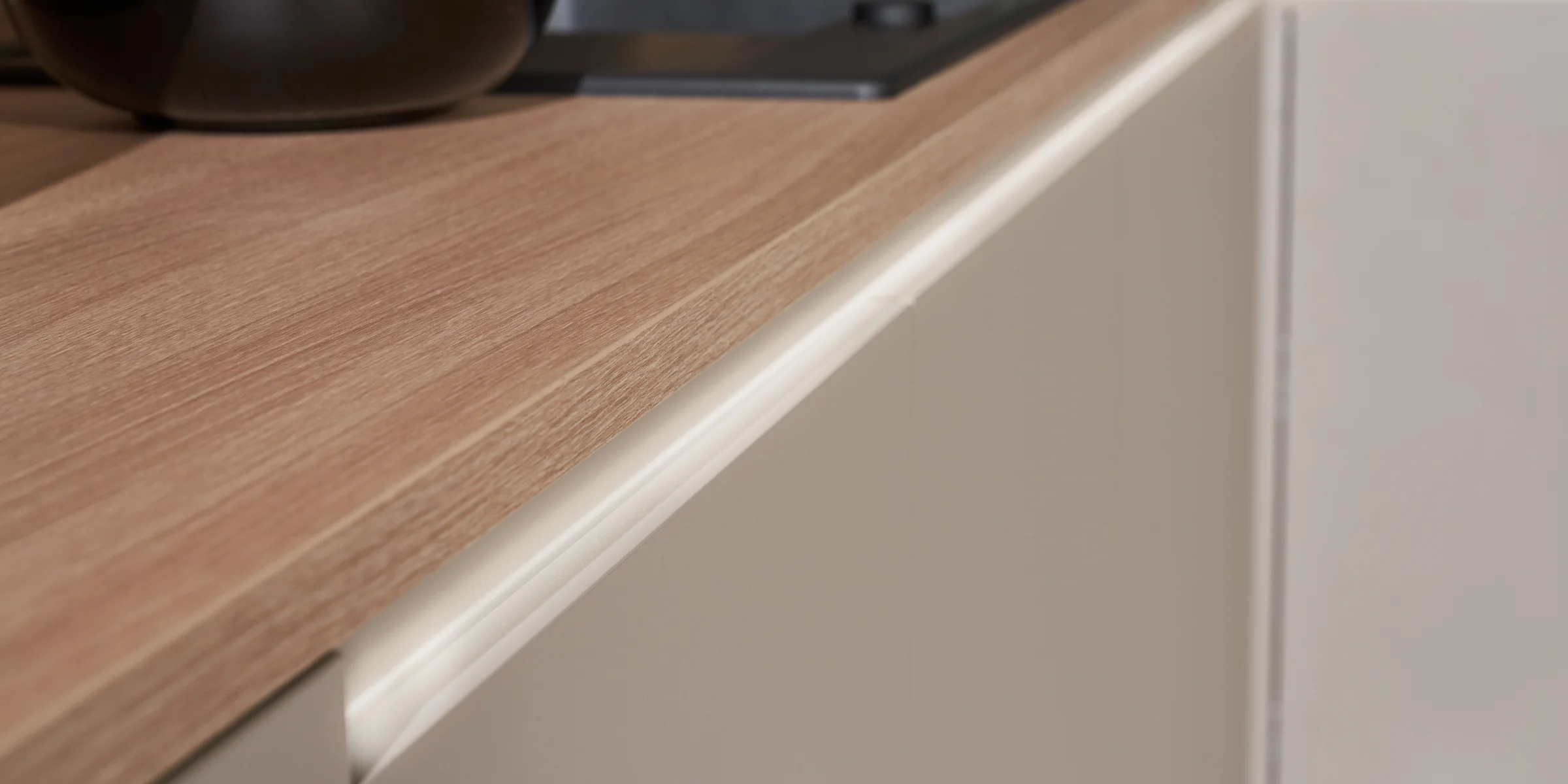 Cucina moderna con piano in legno e mobili chiari di Nolte Kitchen.