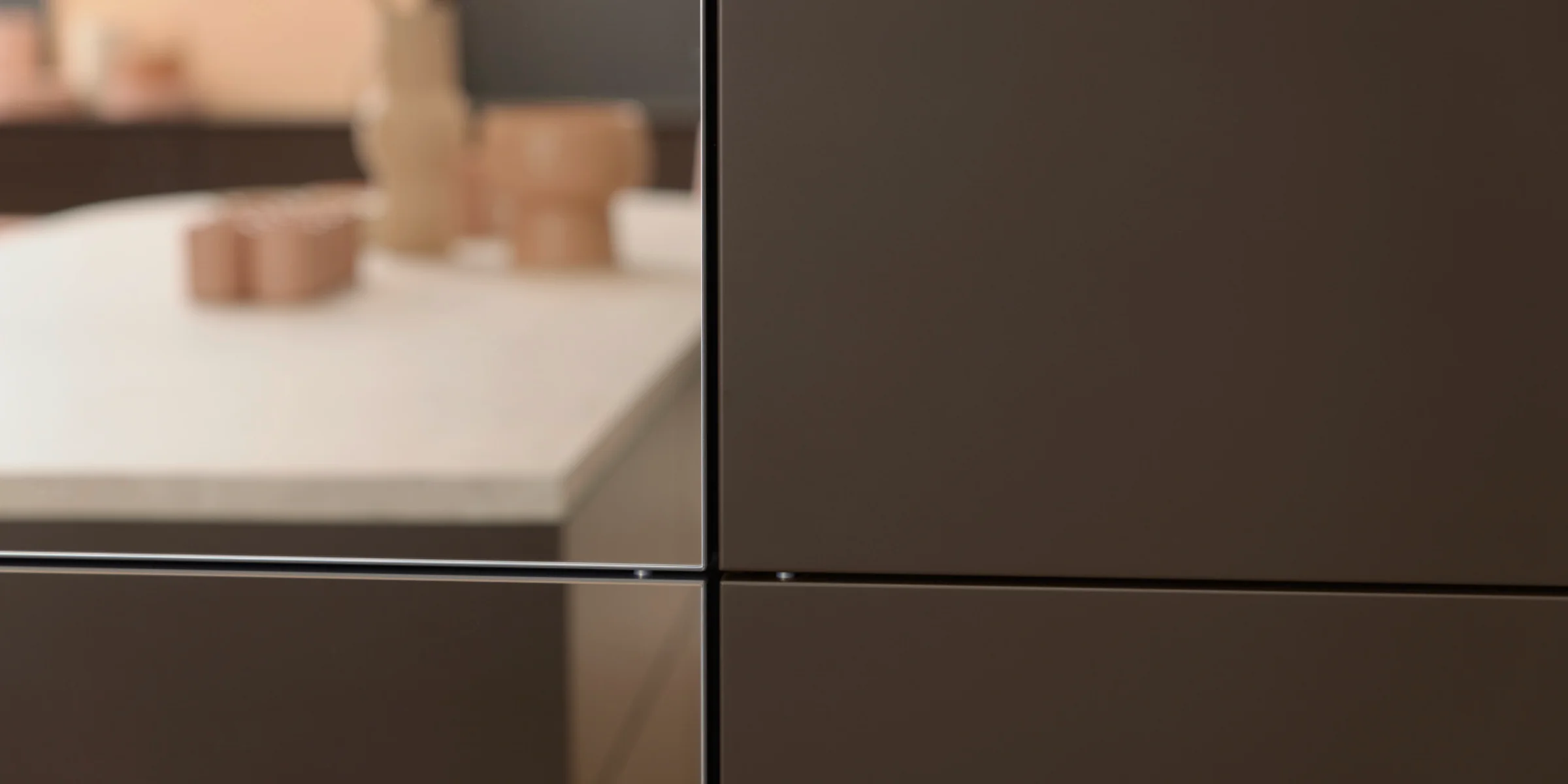 Cucina moderna con armadi scuri e piano di lavoro chiaro, Nolte Kitchen.