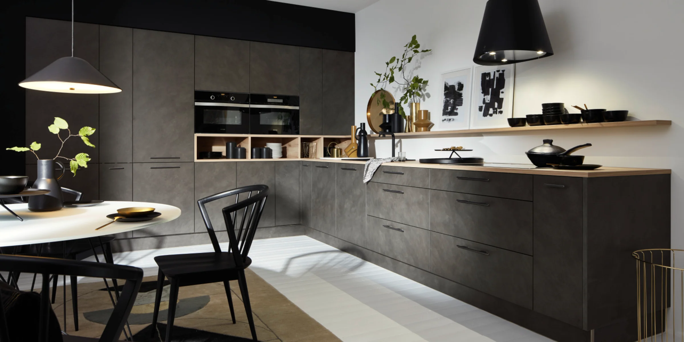Cucina moderna con armadi scuri e illuminazione elegante, progettata da Nolte Kitchen.