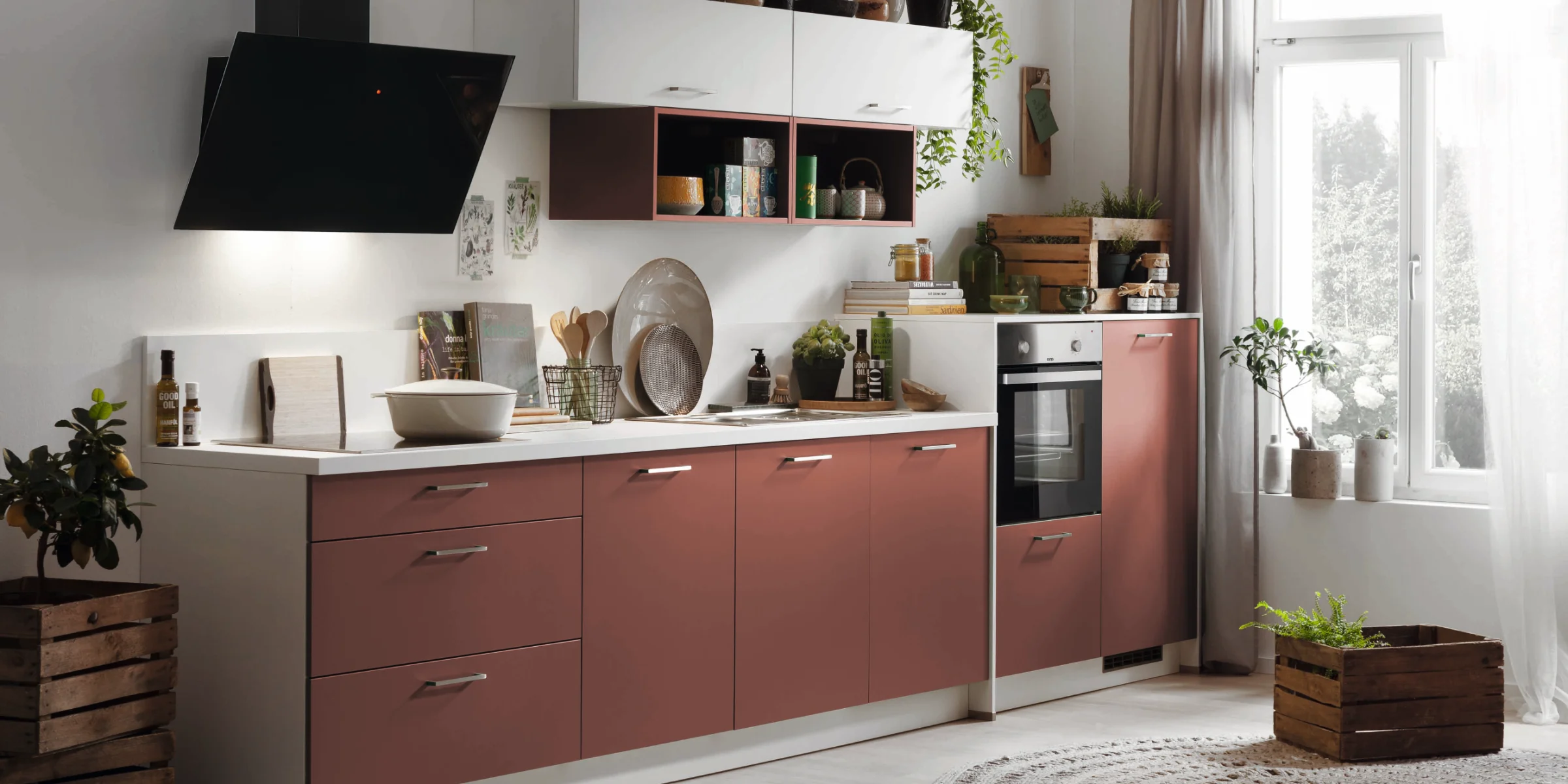 Eine moderne Küche mit roten Schränken, Pflanzen und Küchenutensilien. Express Küchen.