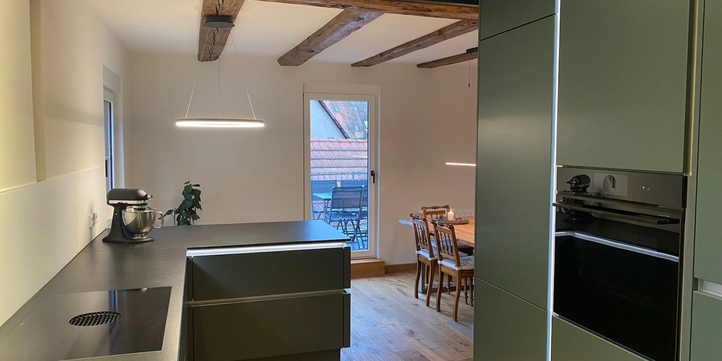 Cucina moderna con dettagli in legno e zona pranzo, presentata da Nolte Kitchen.