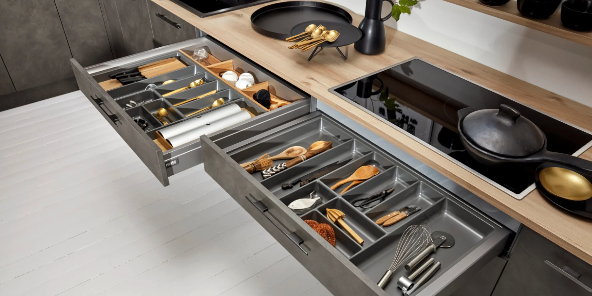 Una cucina moderna con cassetti aperti che mostrano posate e utensili. Nolte Kitchen.