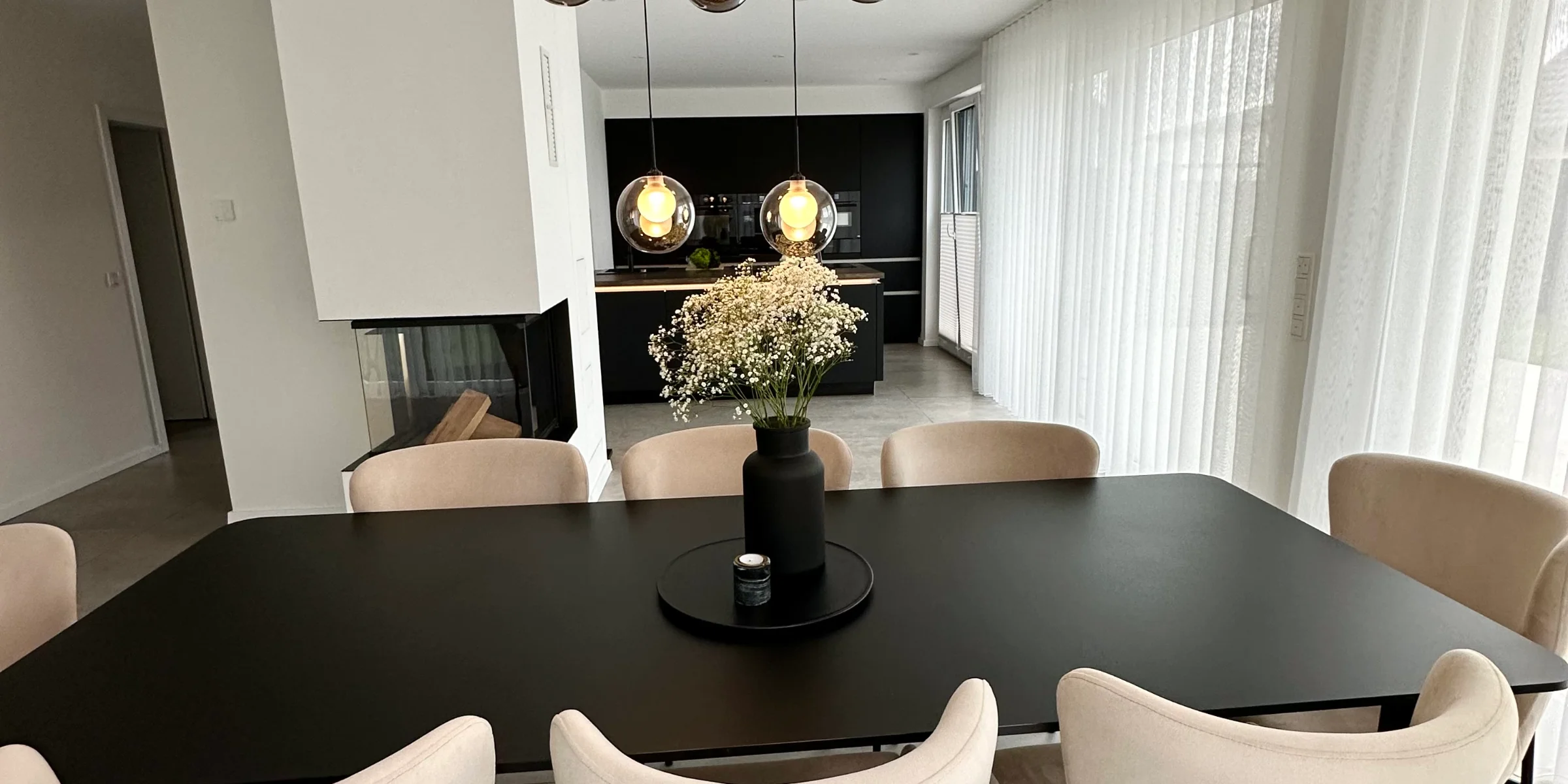 Sala da pranzo elegante con tavolo e sedie moderni, illuminazione di stile, da Nolte Living.