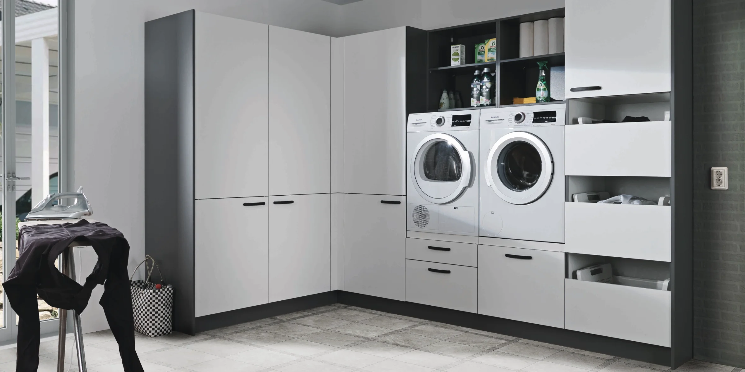Buanderie avec lave-linge et sèche-linge intégrés dans des armoires modernes. Buanderies express.