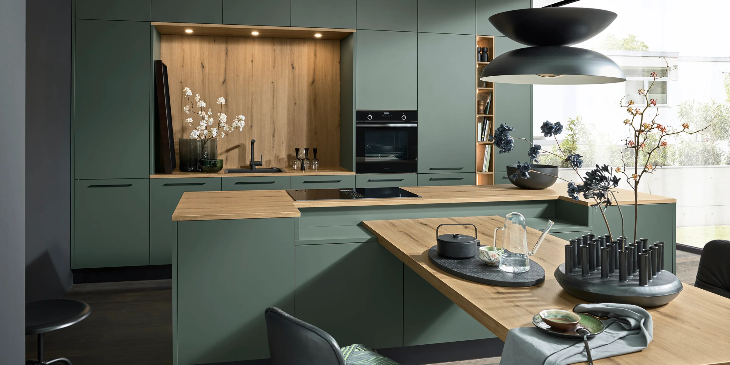 Cucina moderna con armadi verdi e dettagli in legno, design di Nolte Kitchen.
