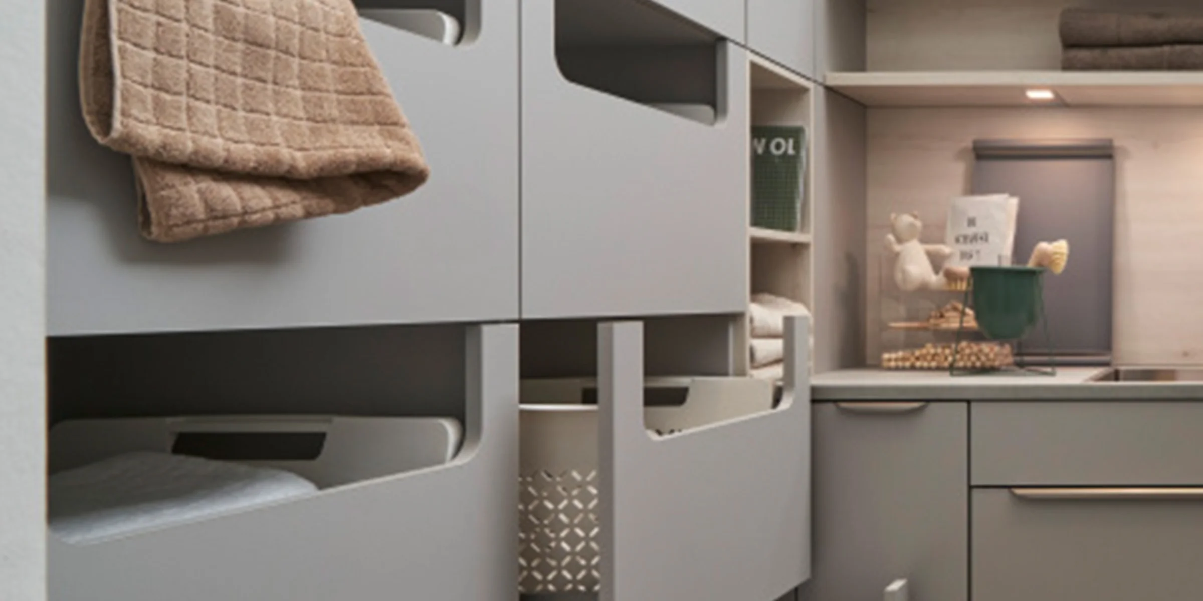 Una moderna lavanderia con armadi e scaffali grigi di Nolte Utility Rooms.