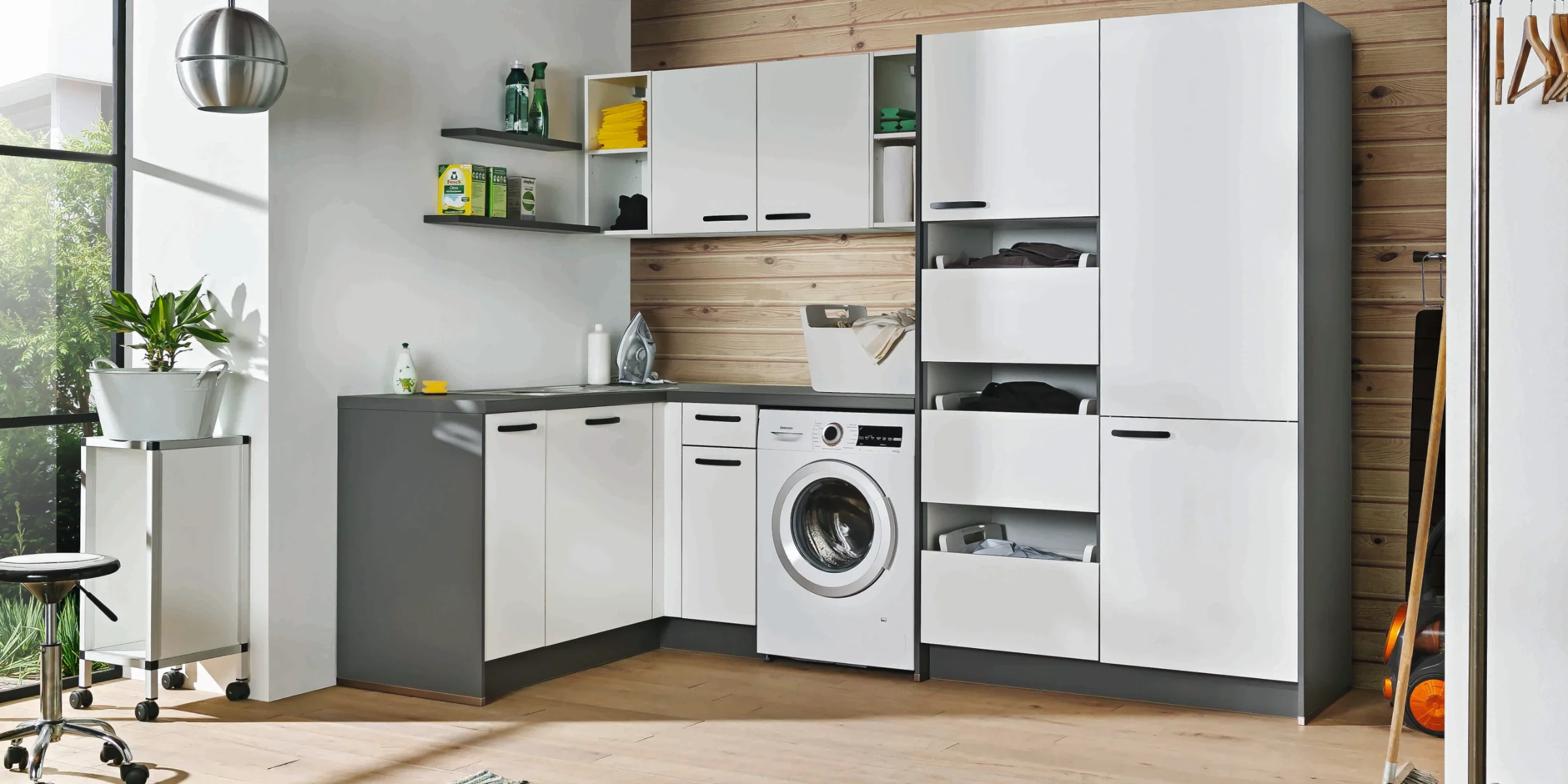 Eine moderne Küche mit Waschmaschine und weißen Schränken; Express Küchen.