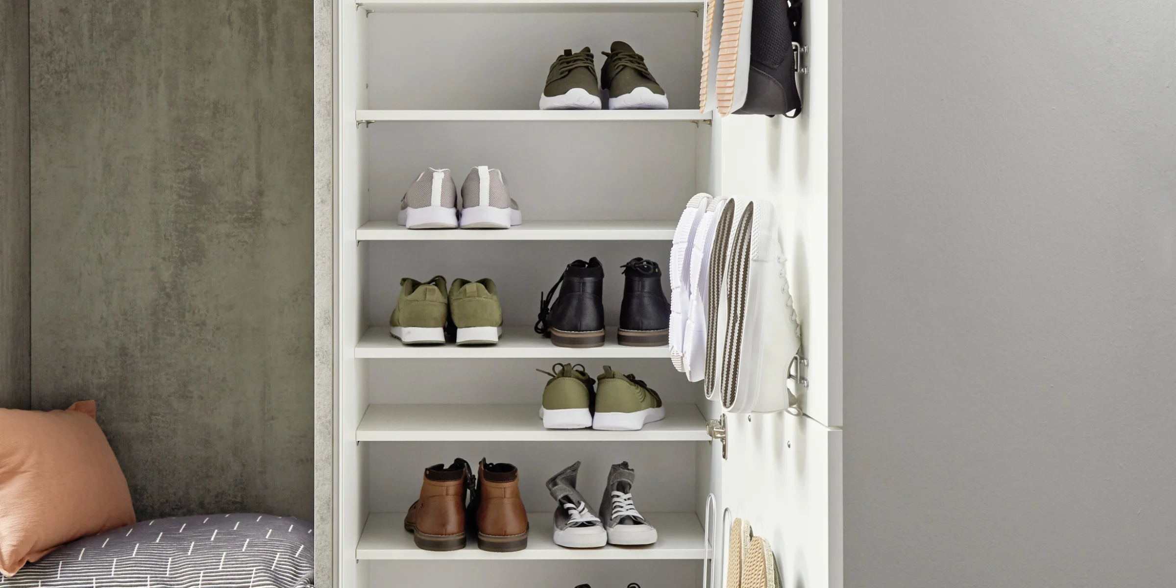 Scarpiera aperta con varie scarpe e area salotto, parte della collezione Nolte Living.