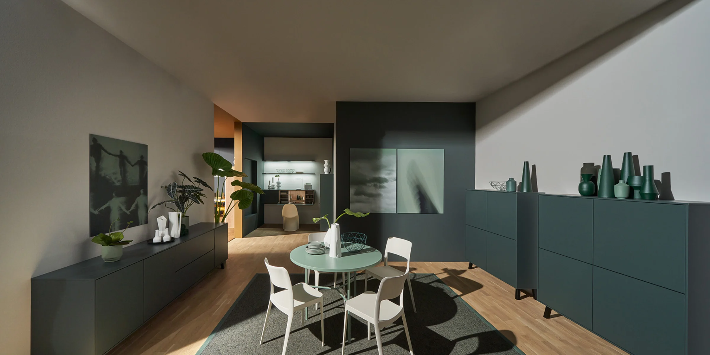 Soggiorno moderno con tavolo da pranzo e armadi, decorato con piante e opere d'arte, Nolte Living.