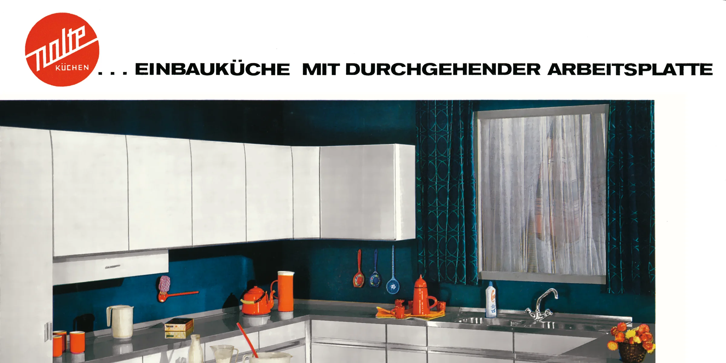 Cucina moderna con arredi chiari e cesto di frutta, presentata da Nolte Kitchen.