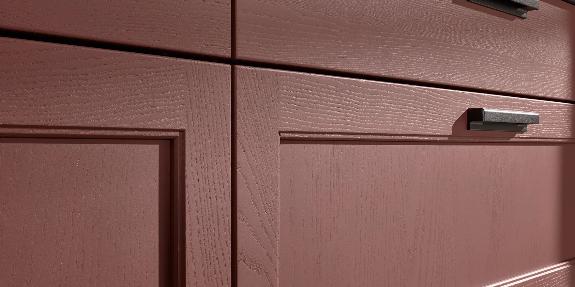 Armadi da cucina rossi con finitura in legno e maniglie moderne, design elegante di Nolte Kitchen.