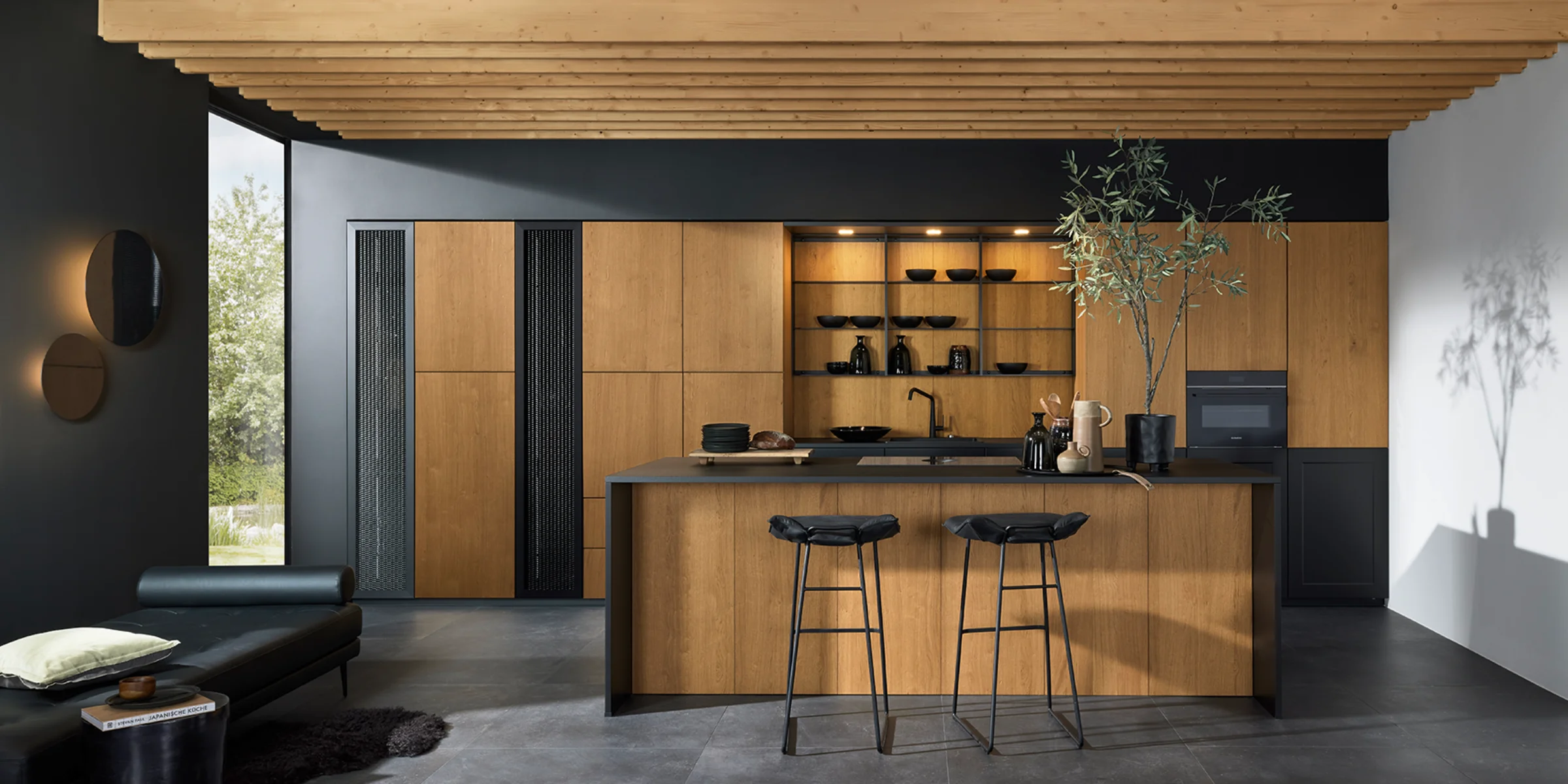 Cucina moderna con elementi in legno e piano di lavoro nero, dotata di cucine Nolte.
