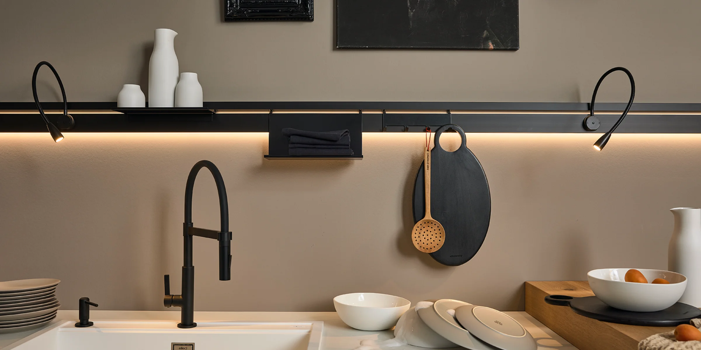 Cucina moderna con rubinetto nero ed elementi decorativi, design di Nolte Kitchen.