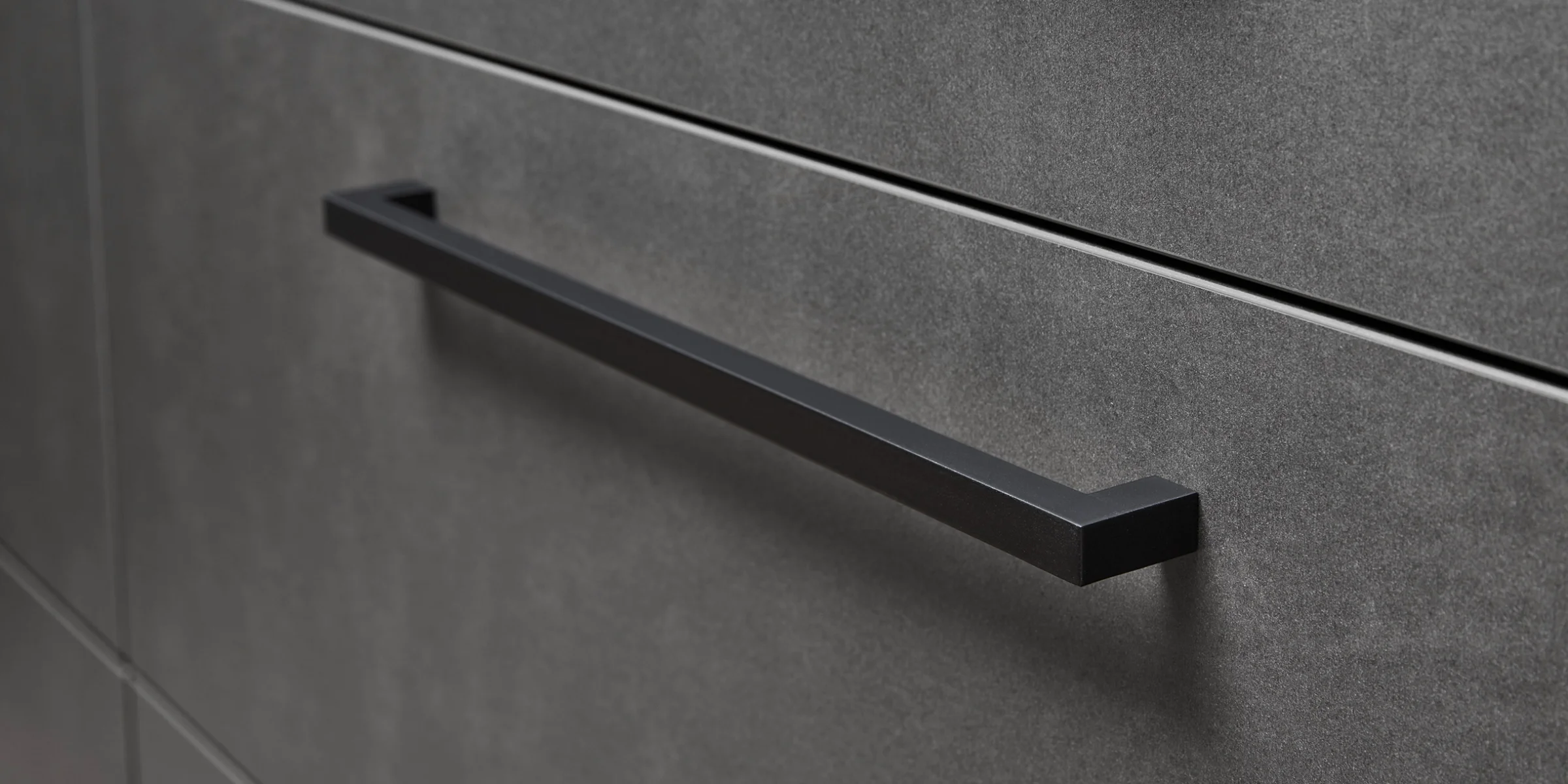 Armadi cucina grigi con maniglie nere, design elegante di Nolte Kitchen.