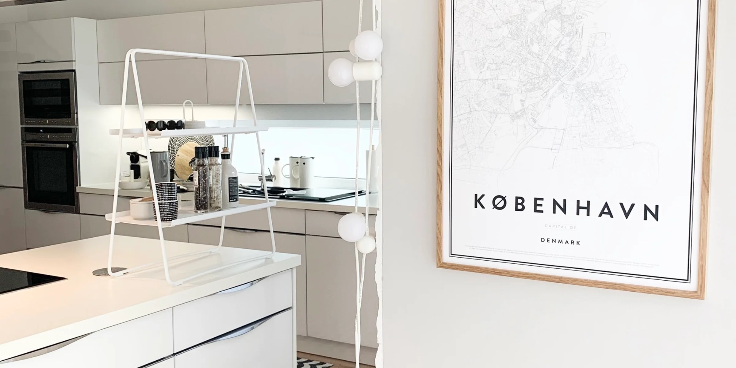 Cucina moderna con armadi bianchi, poster "København" sulla parete. Nolte Kitchen.