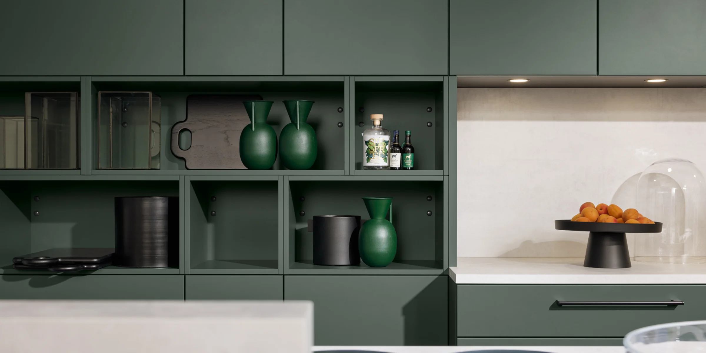 Cucina moderna con armadi verdi e decorazioni, progettata da Nolte Kitchen.