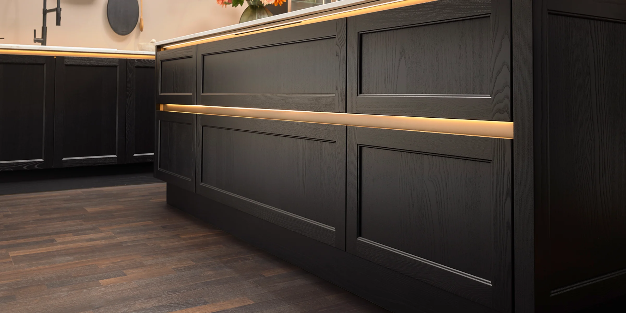 Modern kitchen with dark cabinets and flowers on the countertop, Nolte Kitchen.