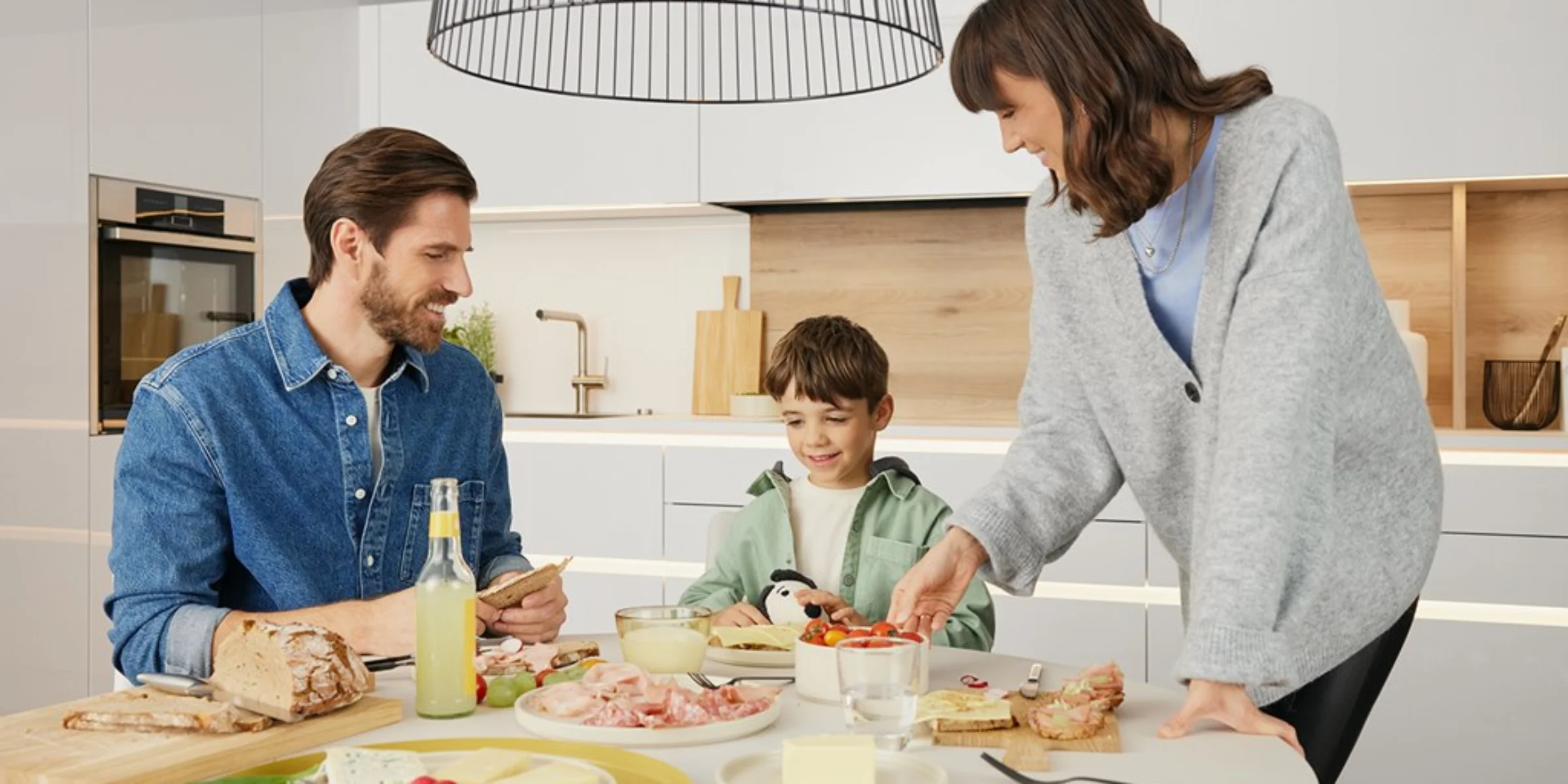 Una famiglia prepara la colazione in una cucina moderna, Nolte Kitchen.