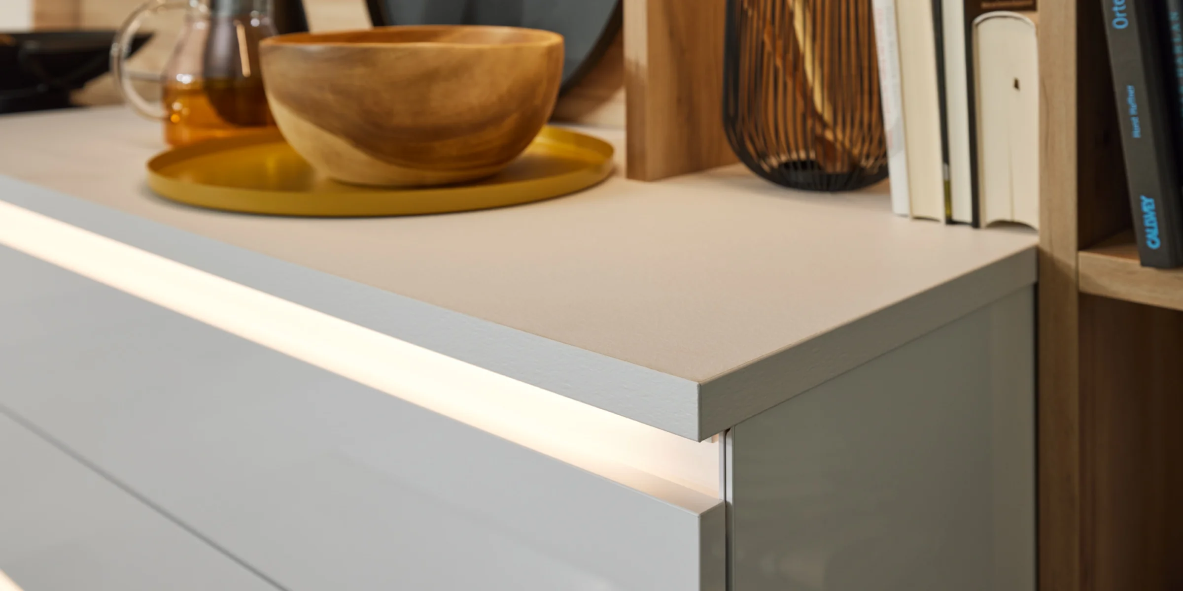 Un moderno bancone da cucina con ciotola in legno e utensili da cucina, Nolte Kitchen.