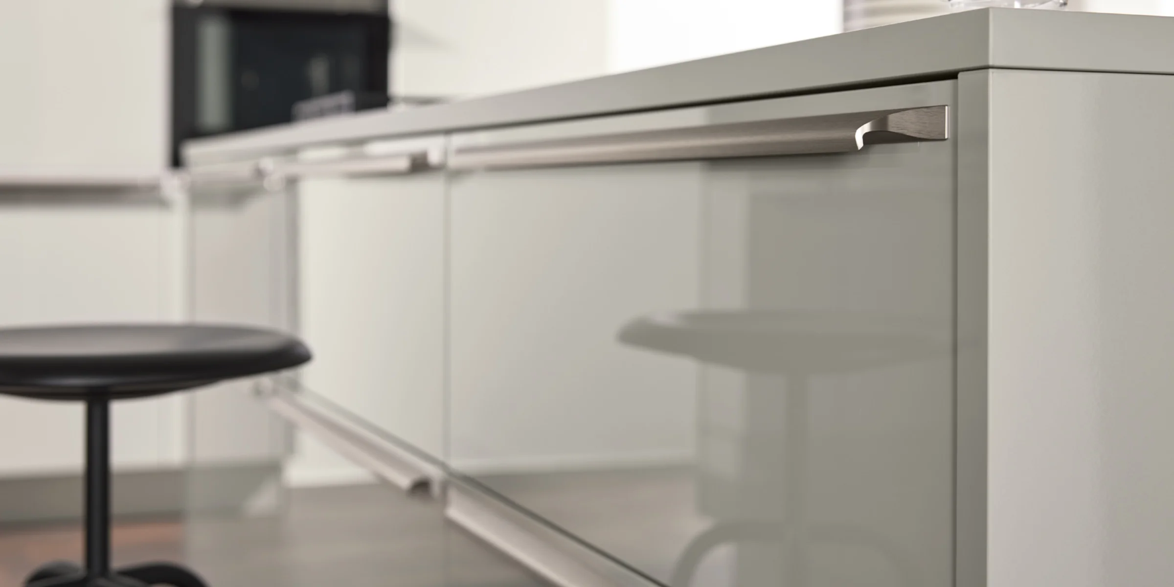 Cucina moderna con superfici lucide e sgabello da bar, Nolte Kitchen.