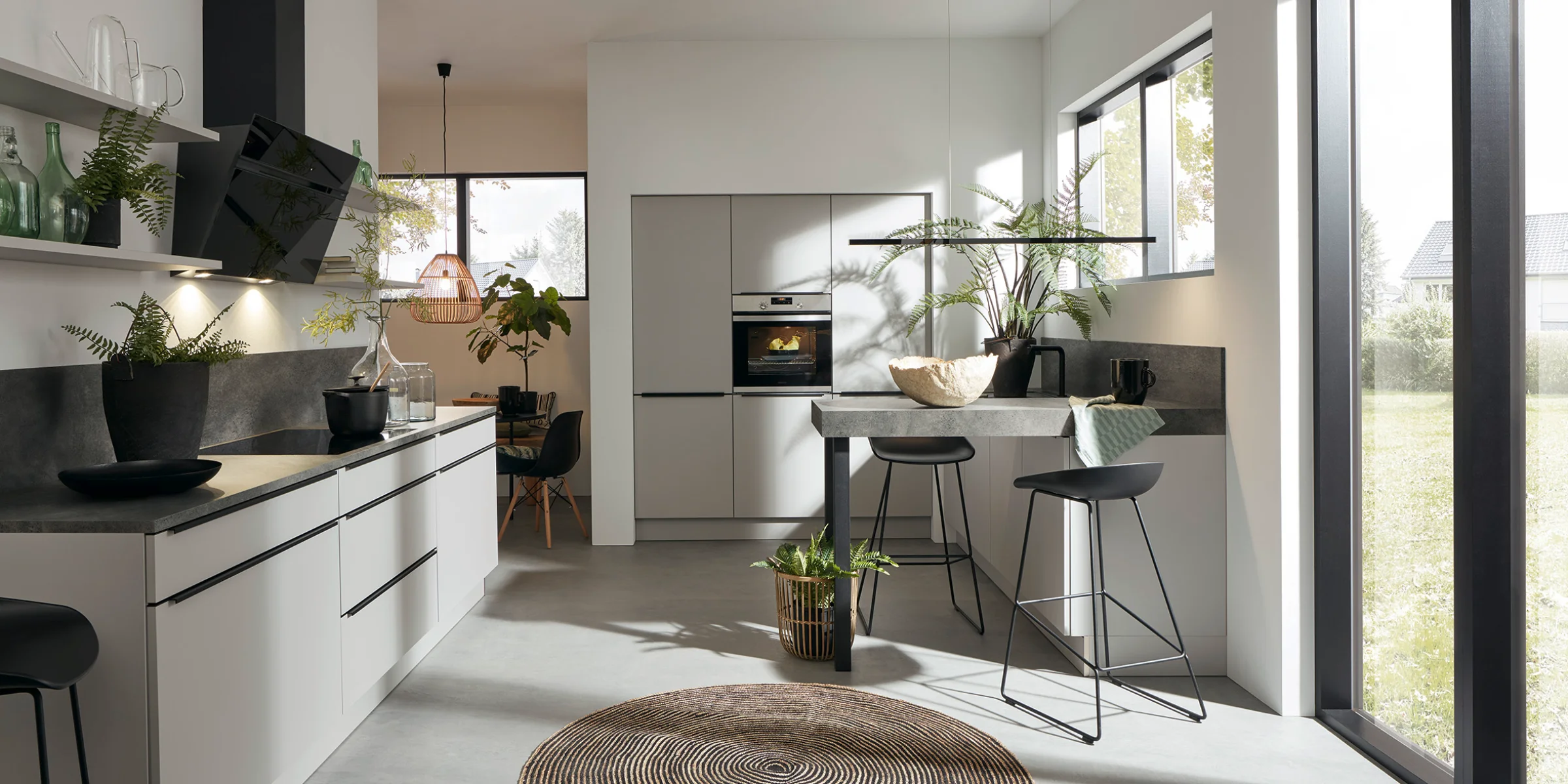 Cucina moderna con isola e grandi finestre, progettata da Nolte Kitchen.