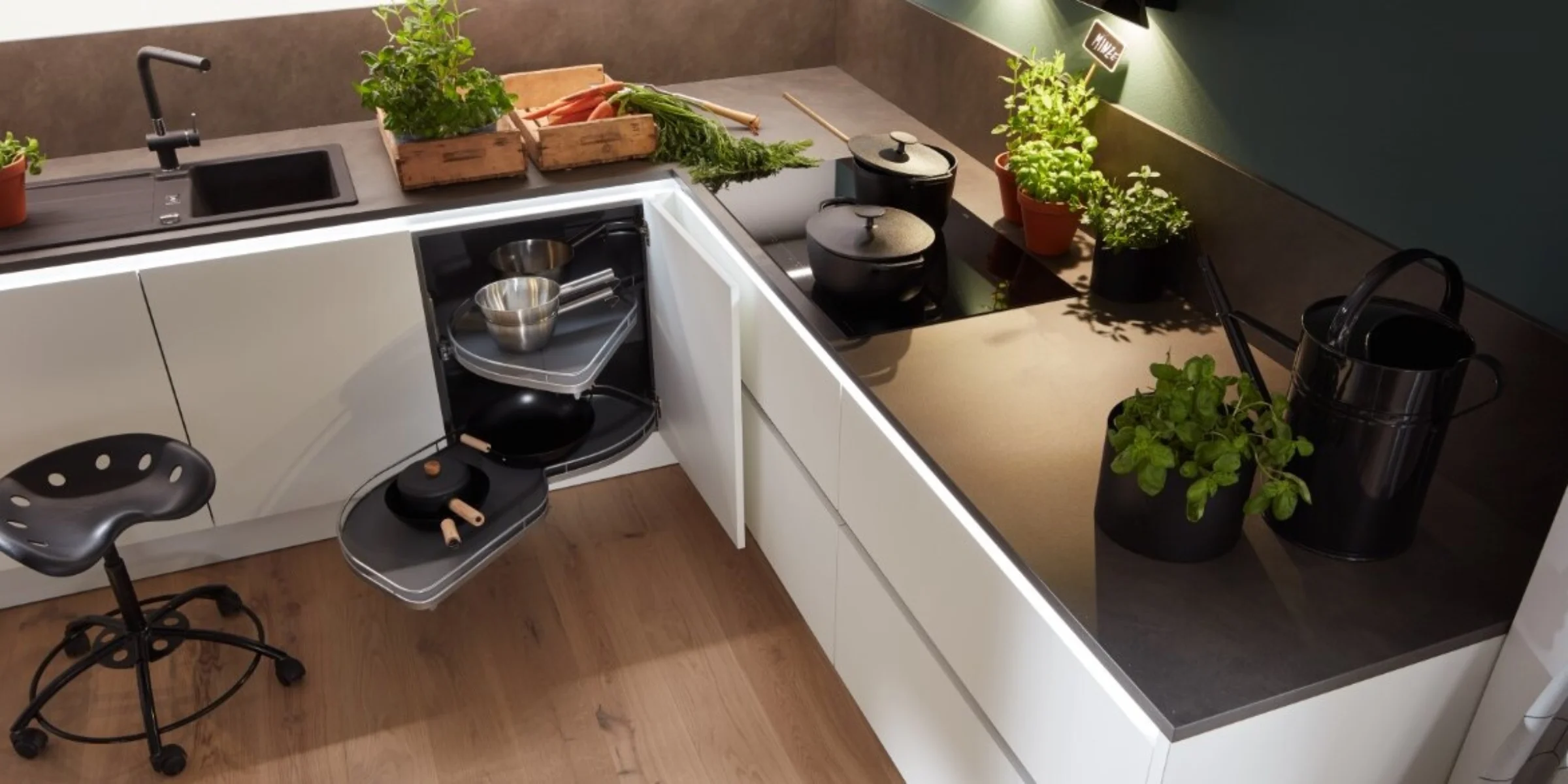 Ergonomicamente progettata cucina Nolte con il Frontenprogramm PLUS in bianco softmatt, altezza di lavoro ottimale e organizzazione dello spazio contenitivo studiata – erbe fresche e cassetti aperti rivelano dettagli cucina smart.