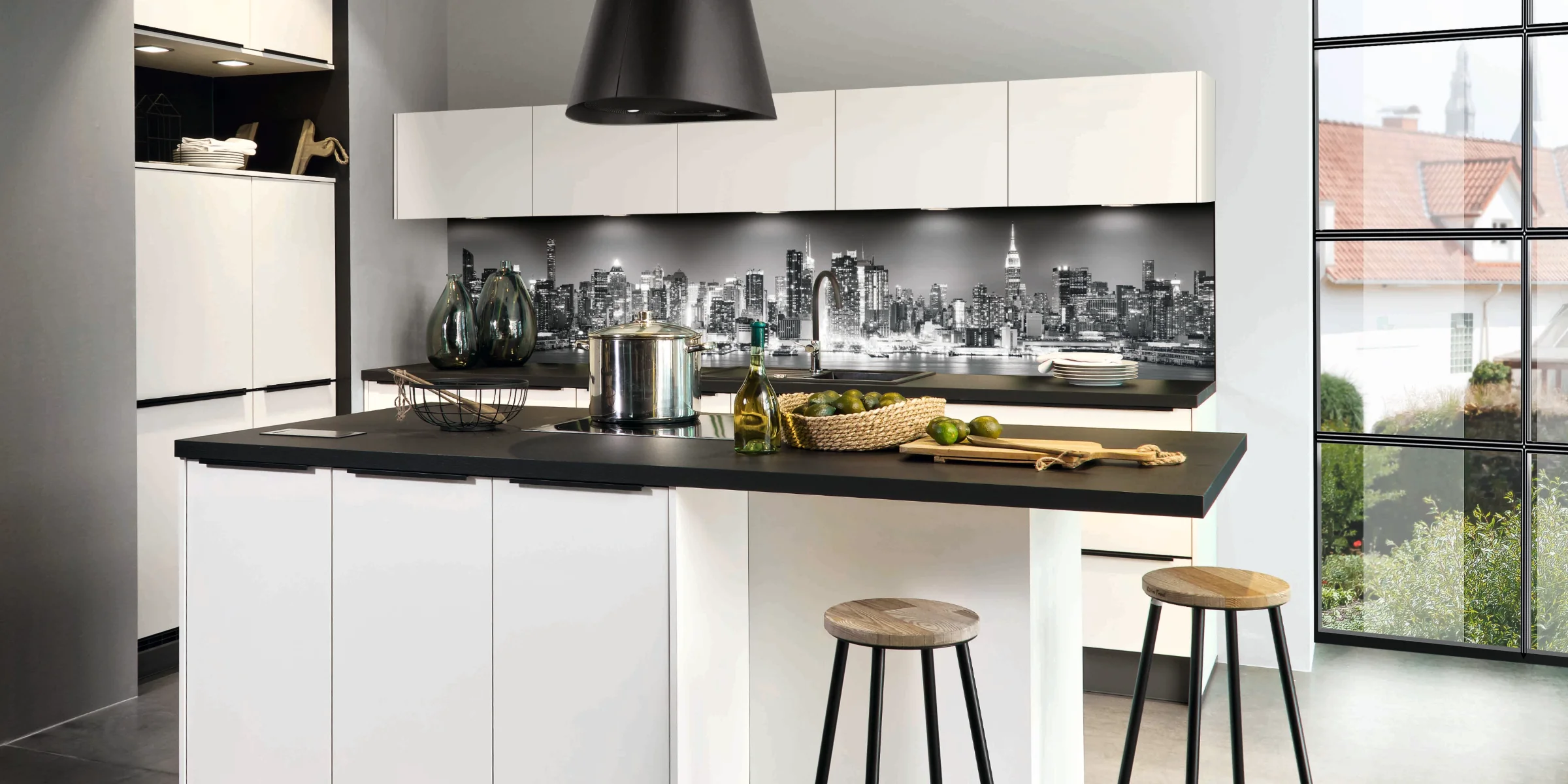 Cuisine moderne avec îlot blanc et tabourets, vue sur la ville. Express Küchen.