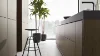 Cucina moderna con isola e sgabelli, piante davanti a una grande finestra sullo sfondo. Nolte Kitchen.