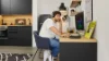 Un uomo lavora in una cucina moderna di Nolte Kitchen, seduto alla scrivania con un computer.