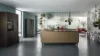 Cucina moderna con isola e accenti di piante, soggiorno sullo sfondo. Nolte Kitchen.
