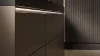 Cucina moderna con eleganti armadi scuri e illuminazione di Nolte Kitchen.