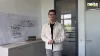 Un uomo in ufficio accanto a progetti e un cartello Nolte Kitchen.