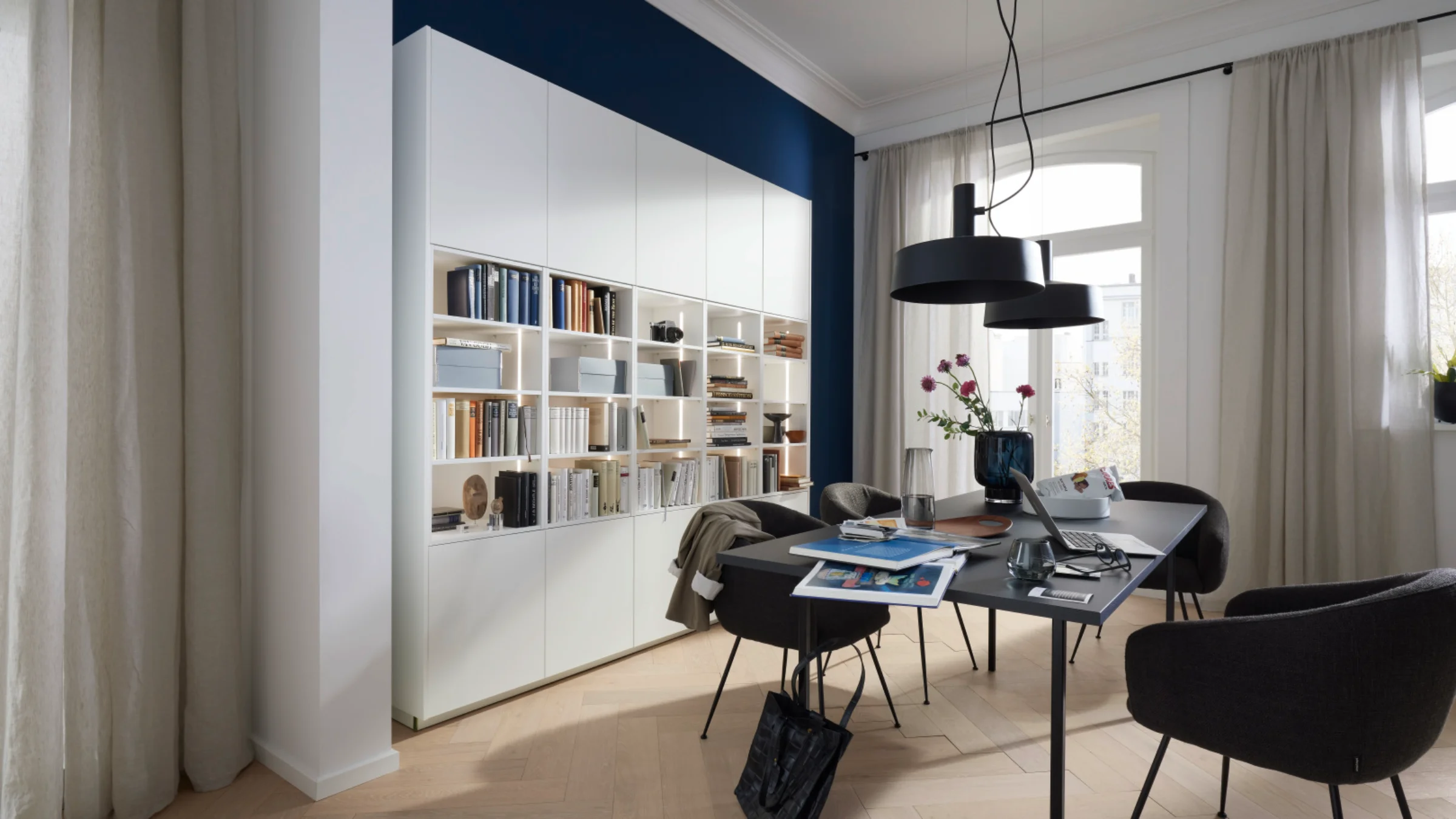 Soggiorno moderno con elegante libreria, tavolo e sedie, in stile Nolte Living.