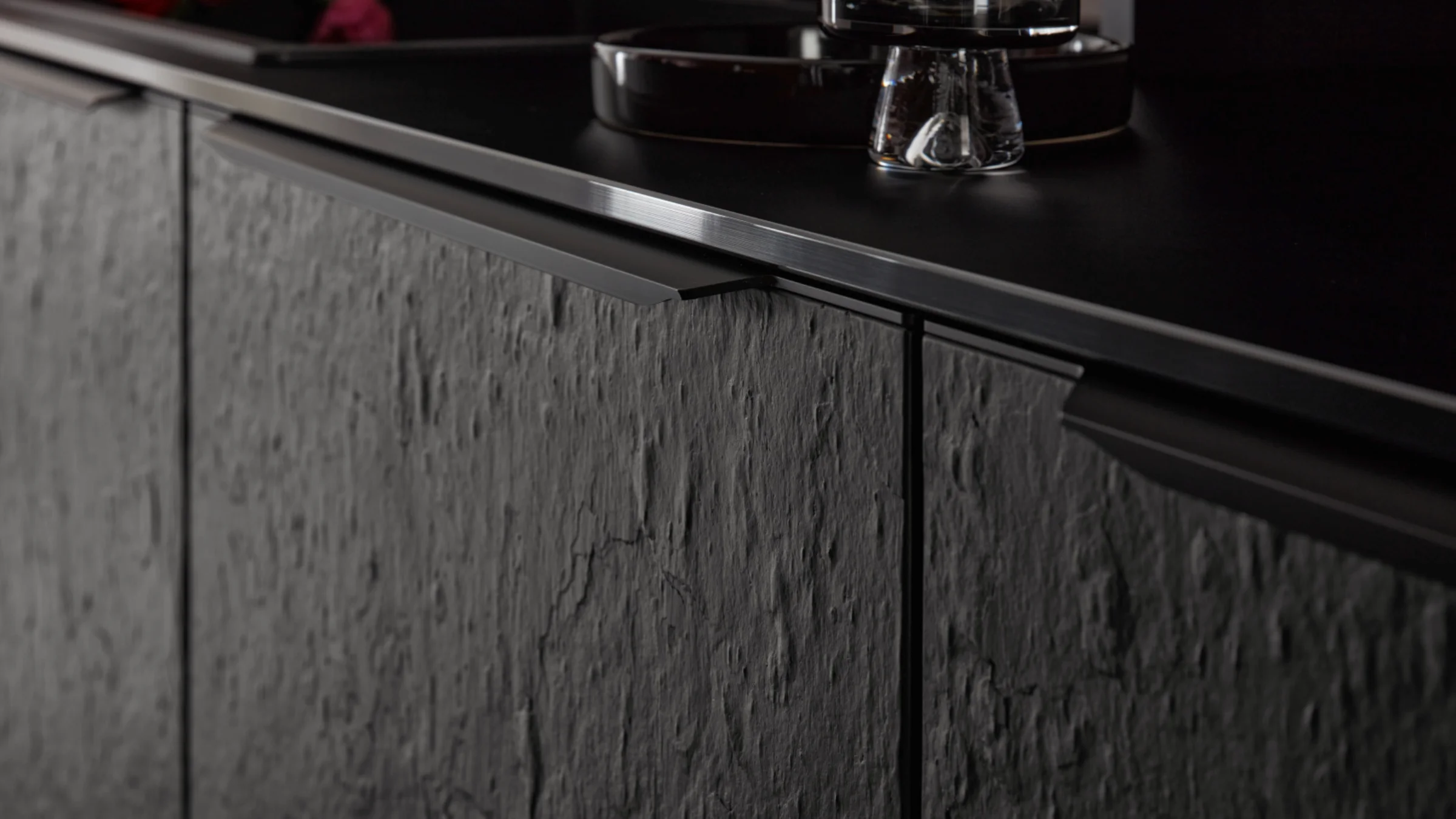 Cucina moderna con frontali scuri e strutturati e dettagli eleganti di Nolte Kitchen.