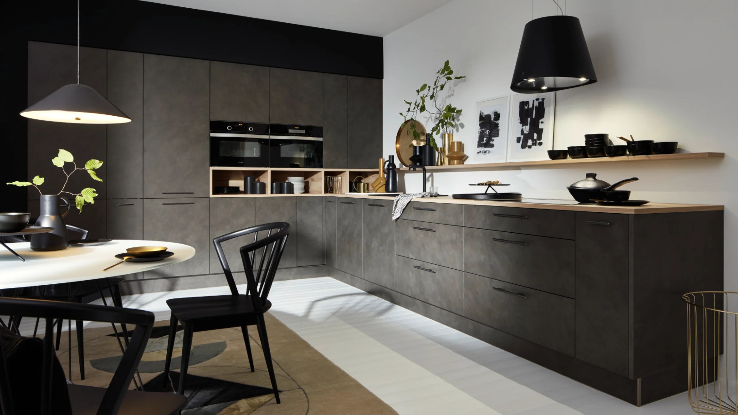 Cucina moderna con armadi scuri e illuminazione elegante, progettata da Nolte Kitchen.